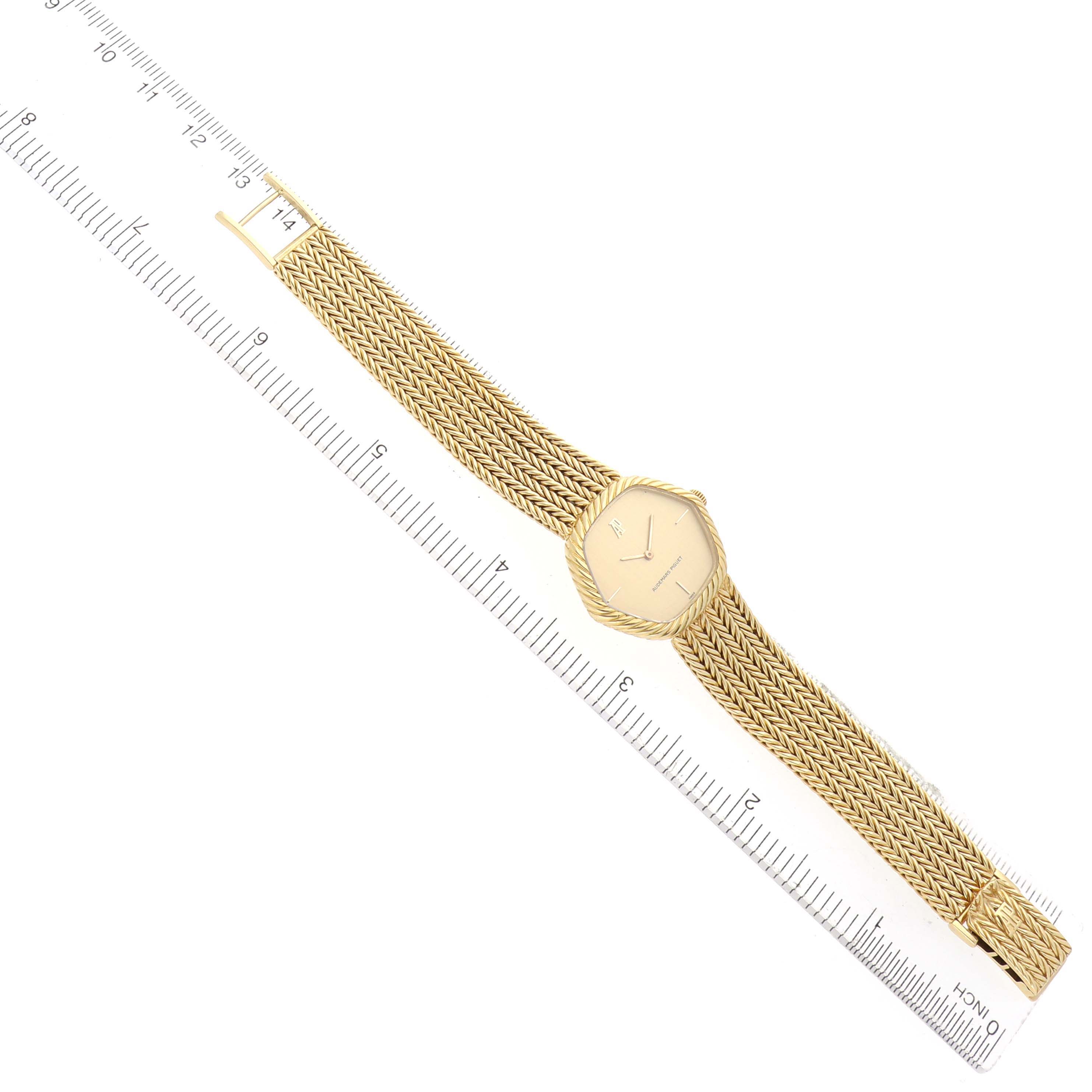 The vintage Audemars Piguet watch is shown at a slight diagonal angle, displaying its dial, intricate gold bracelet, and buckle.