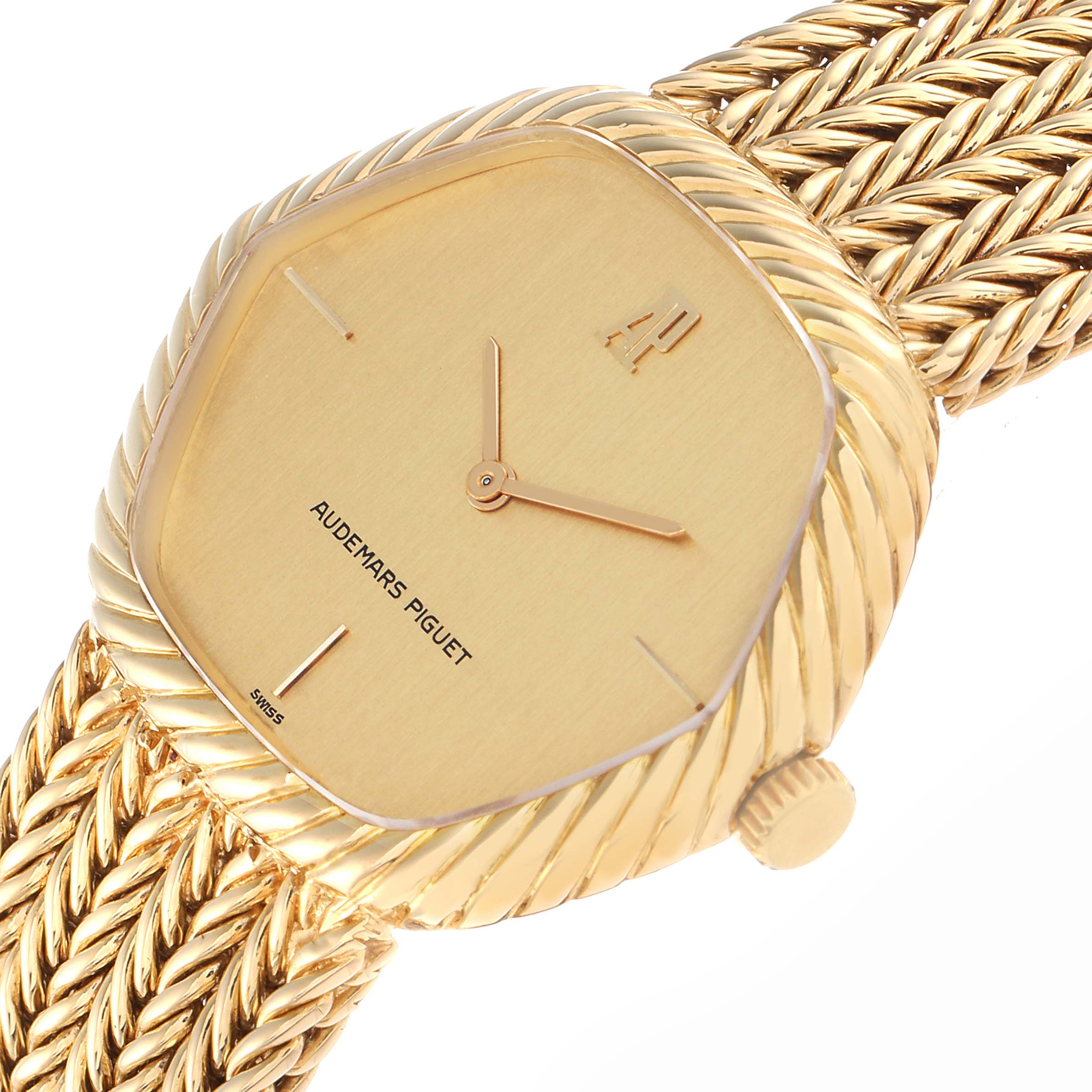 The Audemars Piguet Vintage Men
s Yellow Gold Champagne Dial watch is shown at an angled close-up, highlighting the gold face, hands, and intricately braided band.