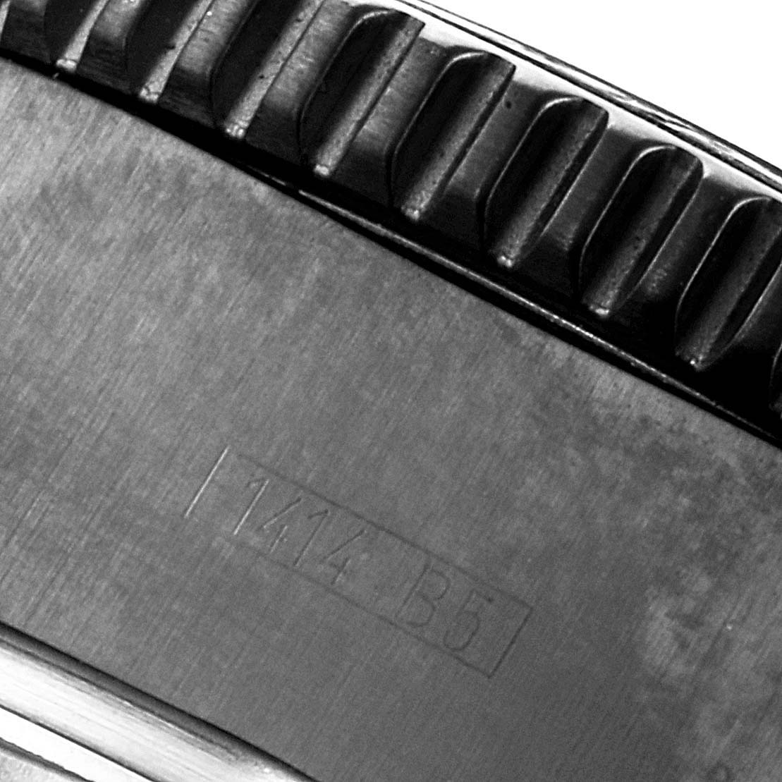 The image shows a close-up of the knurled bezel edge and part of the engraved case back of a Breitling Superocean M13341 Men's Stainless Steel Black Dial M13341 Men's Stainless Steel Black Dial watch.