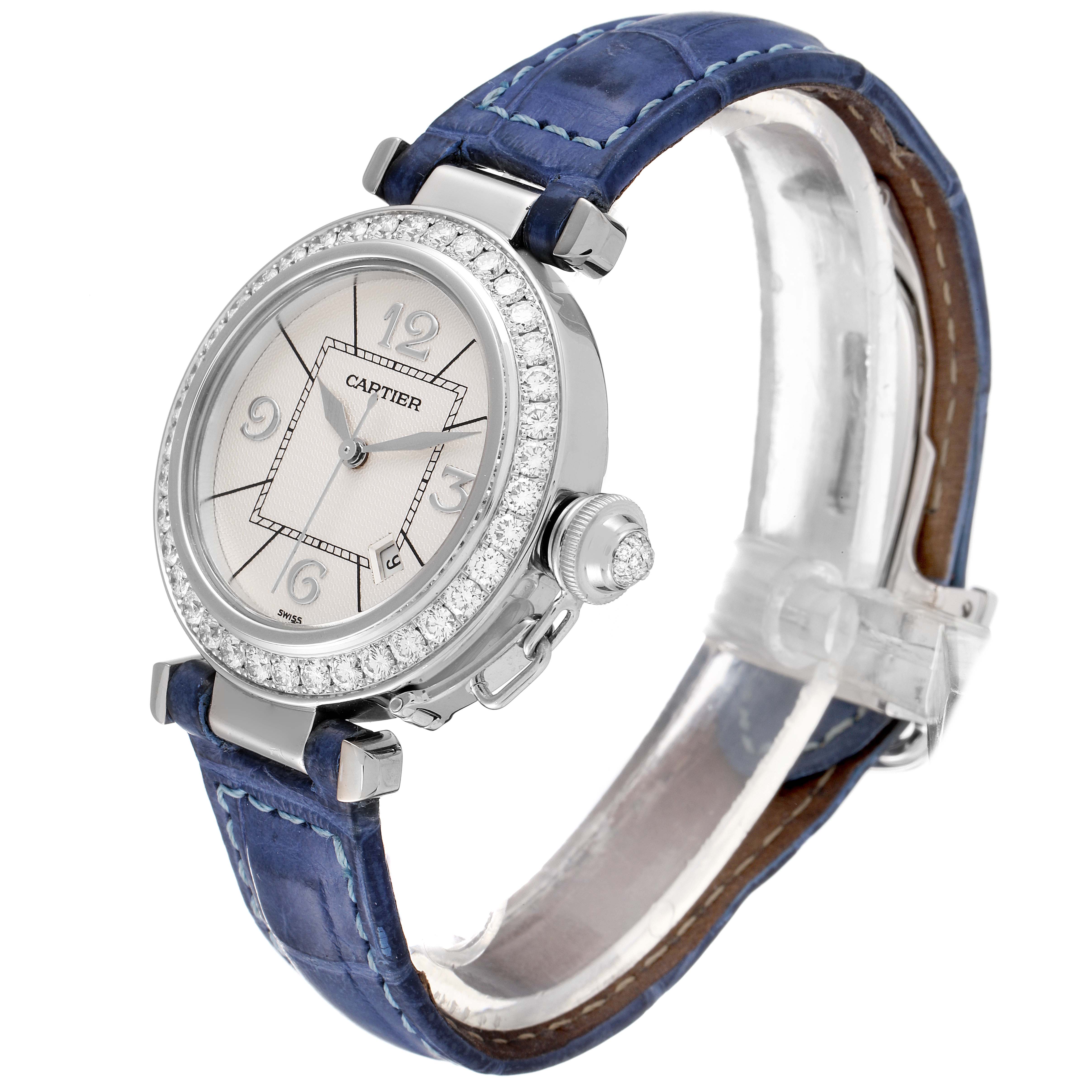 The Cartier Pasha WJ111651 Women's Stainless Steel Silver Dial WJ111651 Women's Stainless Steel Silver Dial watch is shown at a three-quarter angle, showcasing its round face, diamond bezel, and blue leather strap.