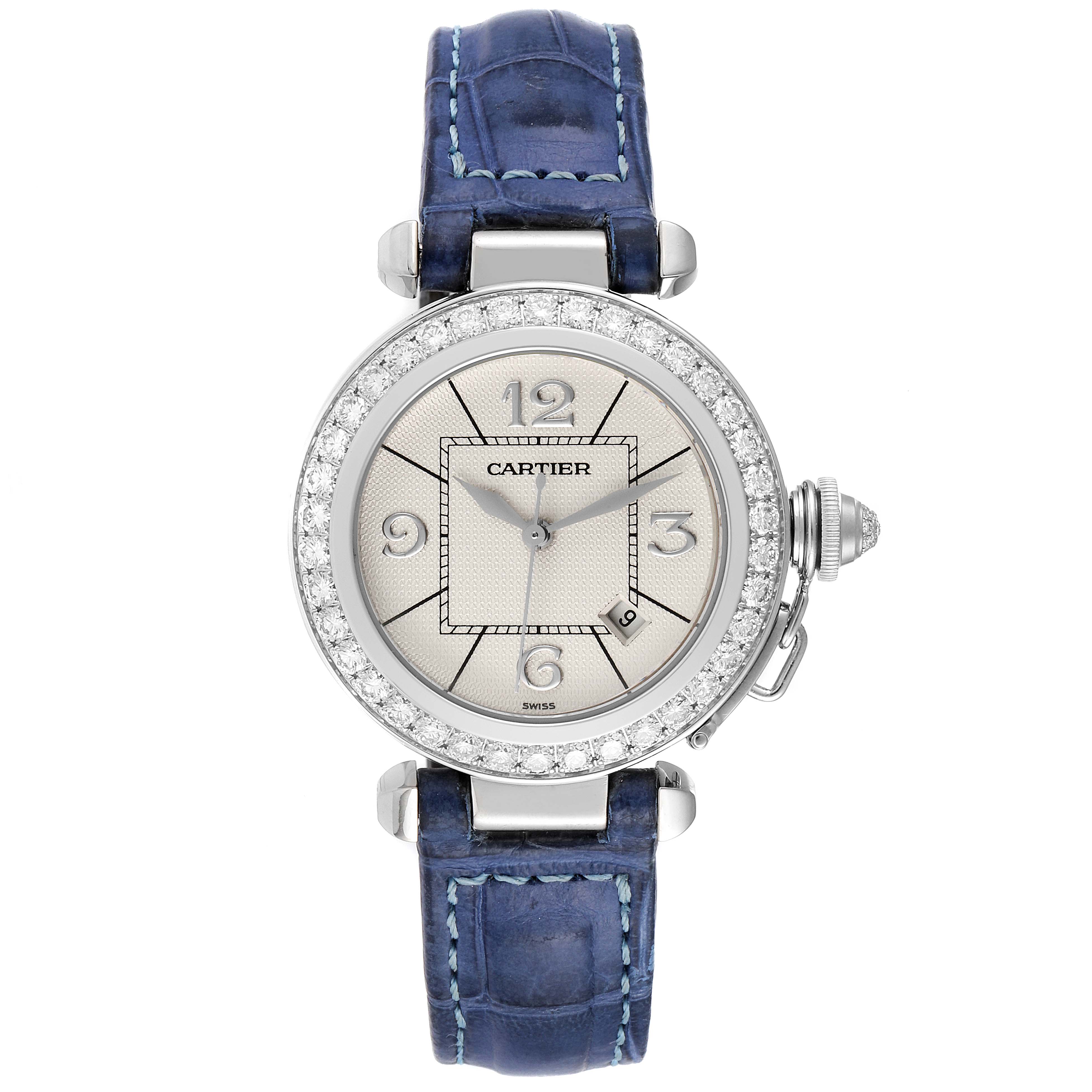 The Cartier Pasha WJ111651 Women's Stainless Steel Silver Dial WJ111651 Women's Stainless Steel Silver Dial watch is shown from a top-down angle displaying the dial, diamond bezel, and blue leather strap.