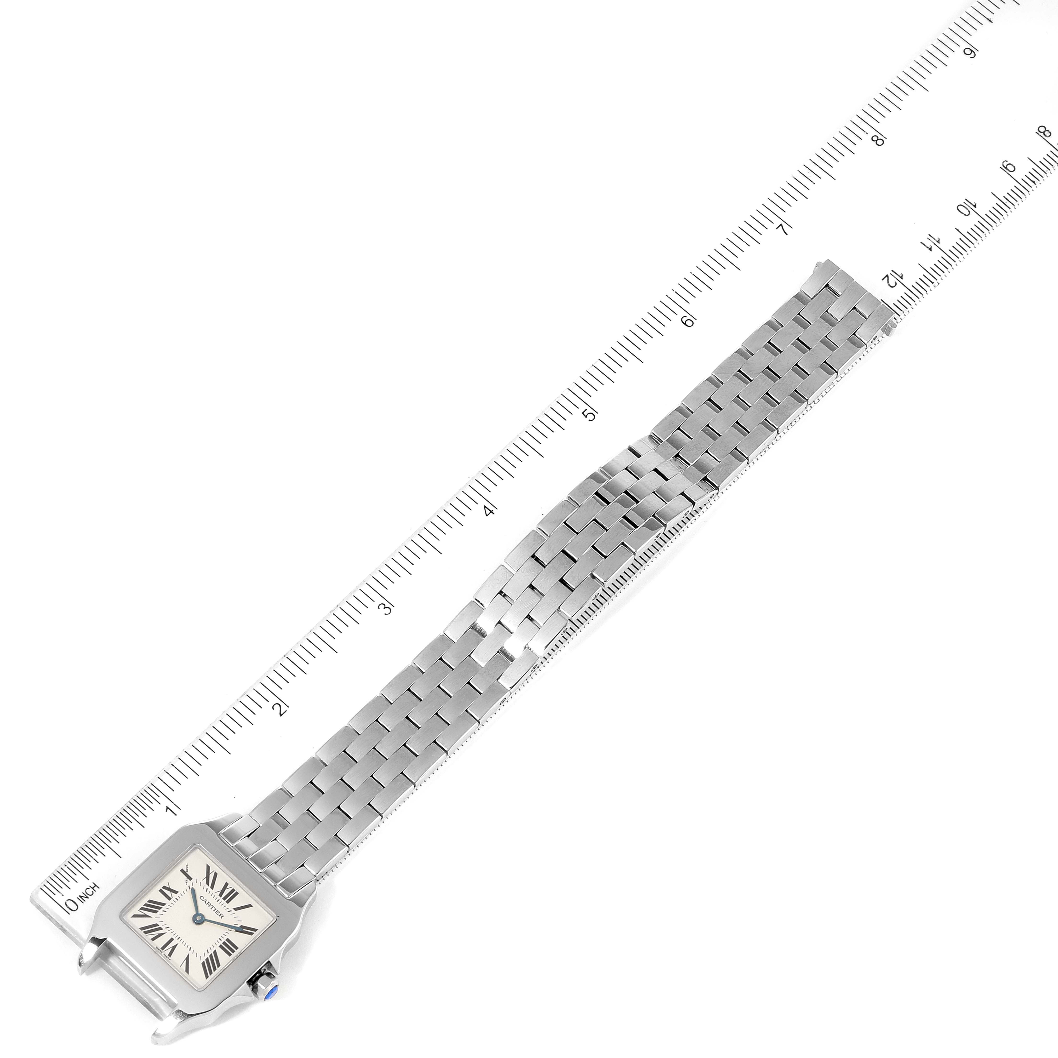 This image shows the Cartier Santos Demoiselle W25065Z5 Women
s Stainless Steel Silver Dial W25065Z5 Women
s Stainless Steel Silver Dial watch laid flat with a ruler along its length for measurement.