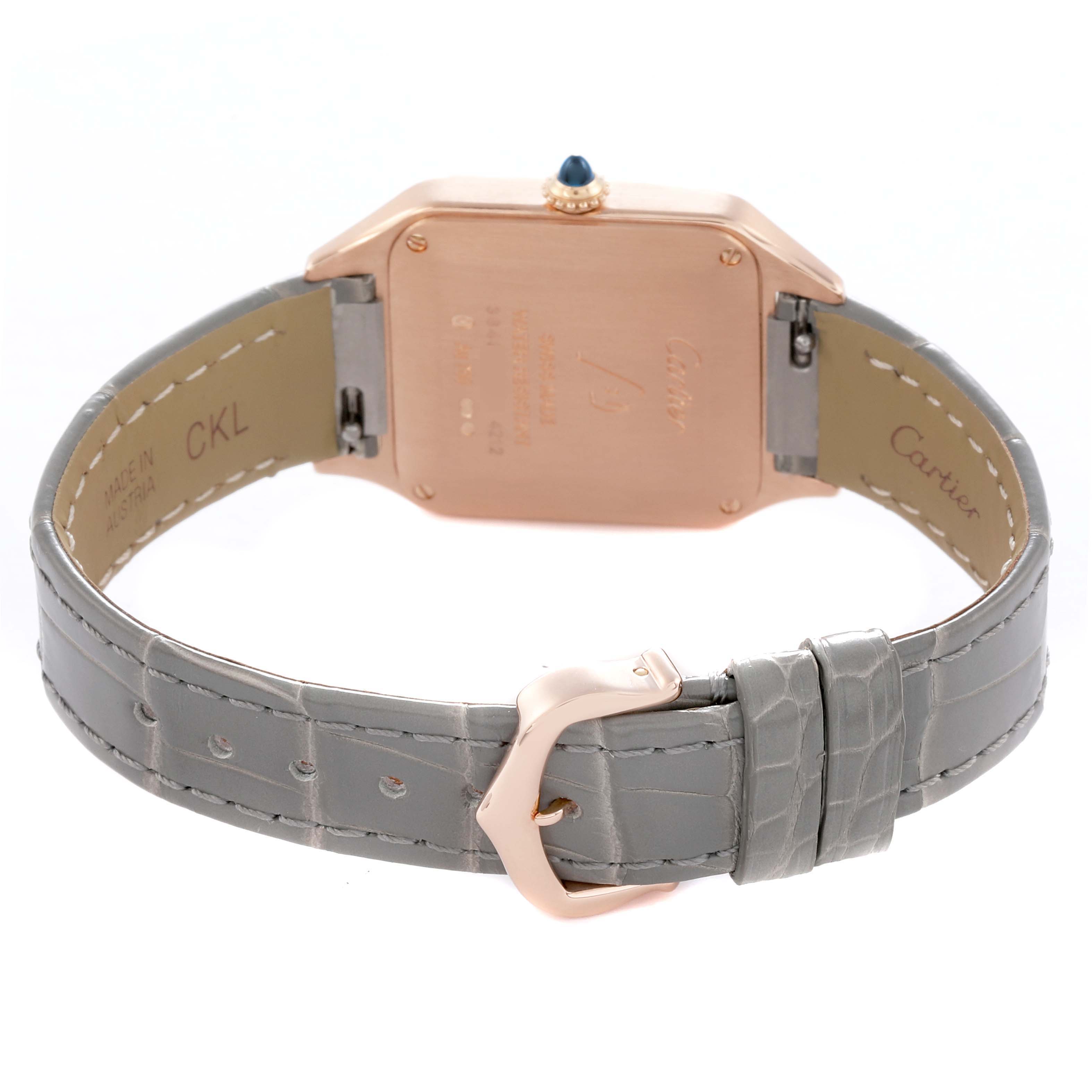 The image shows the back of the Cartier Santos Dumont WGSA0022 Men's Rose Gold Silver Dial watch, highlighting the case back, crown, and gray strap with a buckle.