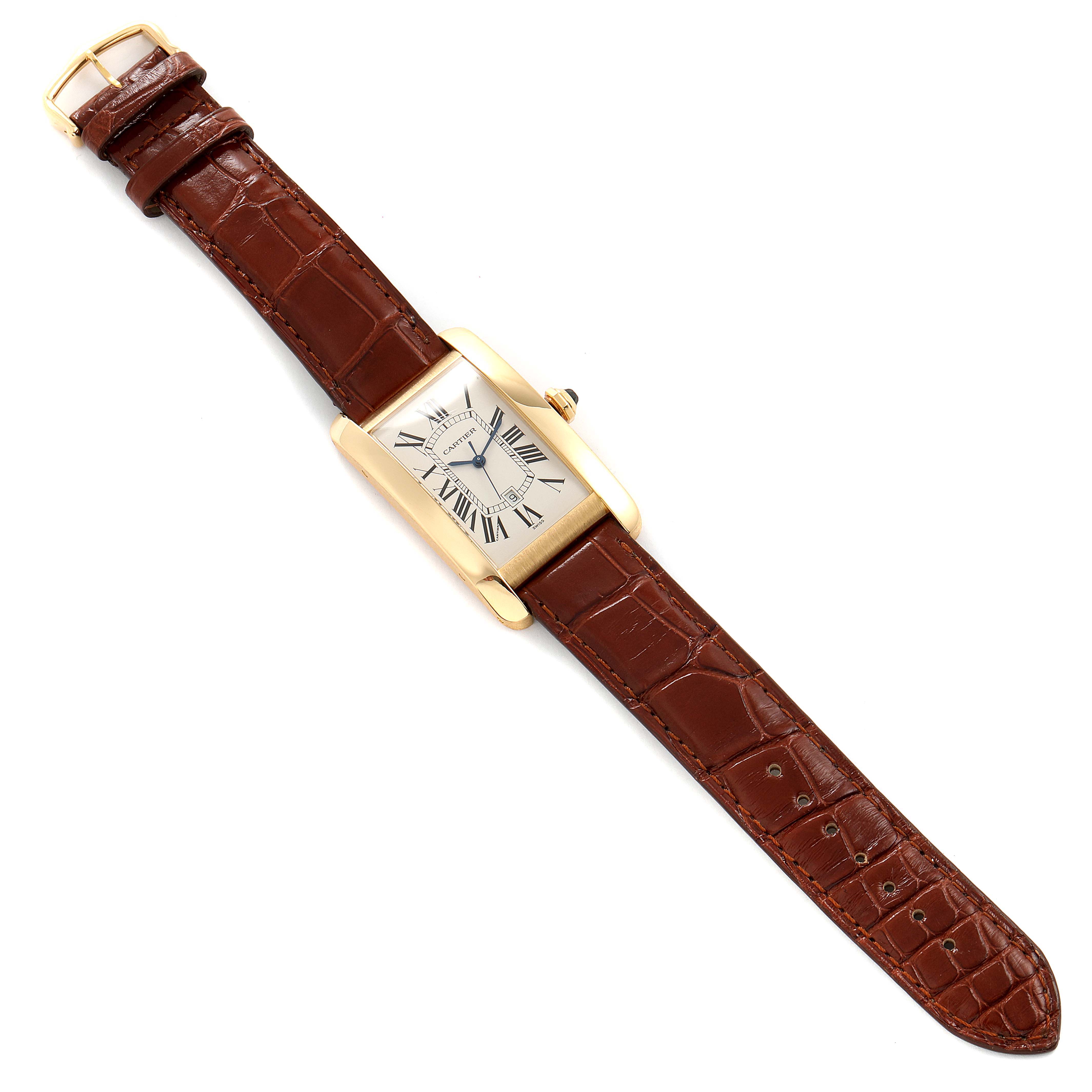 The Cartier Tank Americaine W2603156 Men
s Yellow Gold Silver Dial W2603156 Men
s Yellow Gold Silver Dial watch is shown laid flat, displaying its rectangular face and brown leather strap.