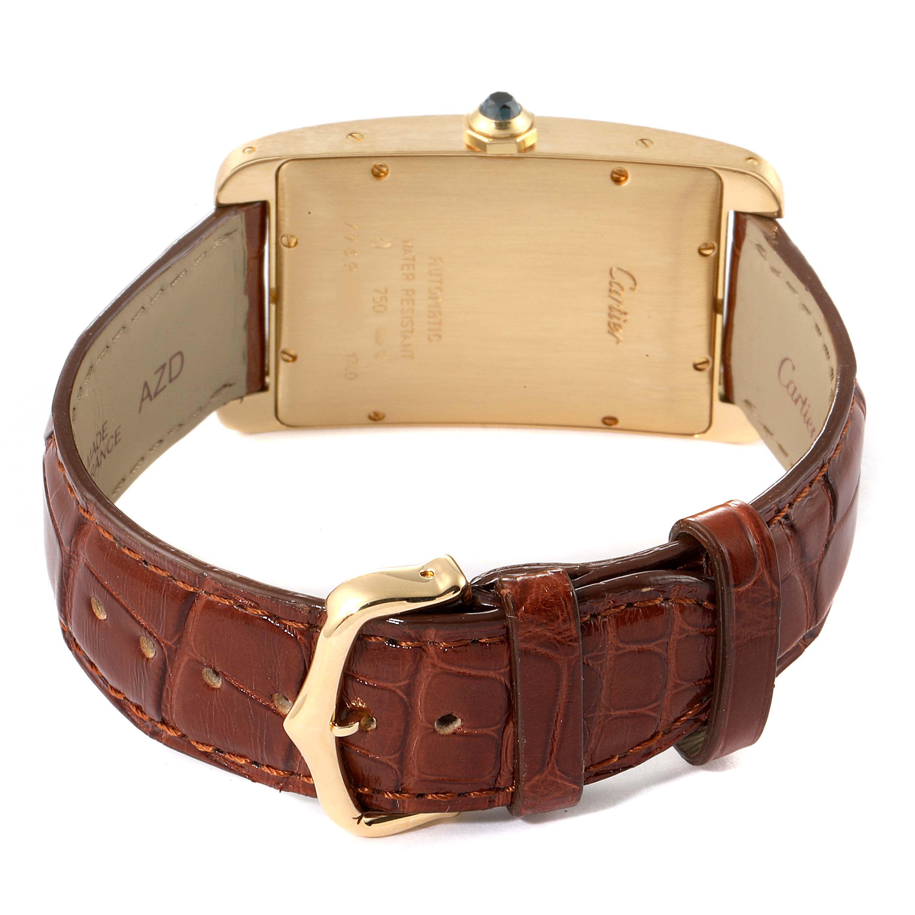 The image shows the back of the Cartier Tank Americaine W2603156 Men
s Yellow Gold Silver Dial W2603156 Men
s Yellow Gold Silver Dial watch and its brown leather strap and gold buckle.