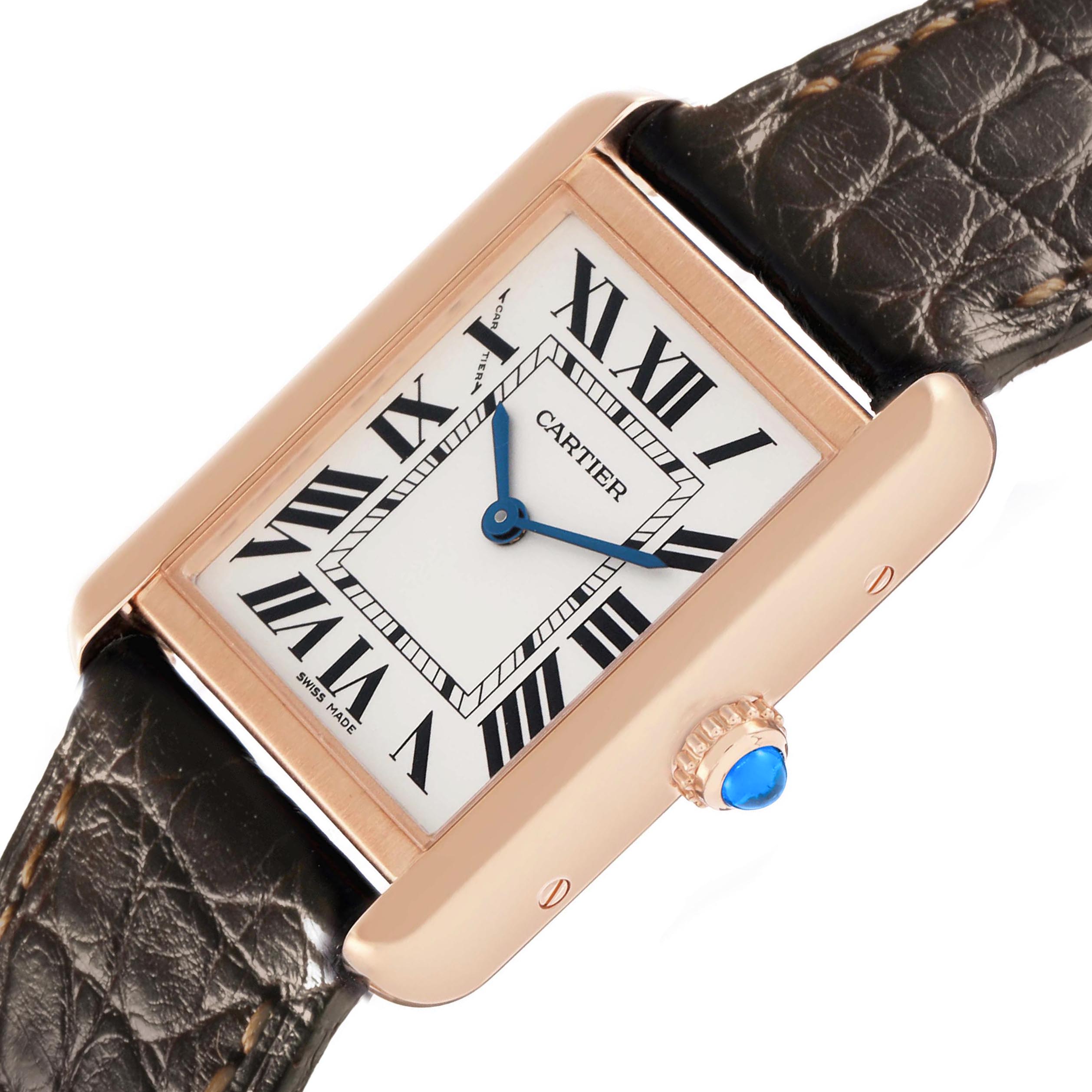 The Cartier Tank Solo W5200024 Women's Rose Gold Silver Dial watch is shown from a top-down angle, highlighting its rectangular case, Roman numerals, blue hands, and crown with a blue cabochon.