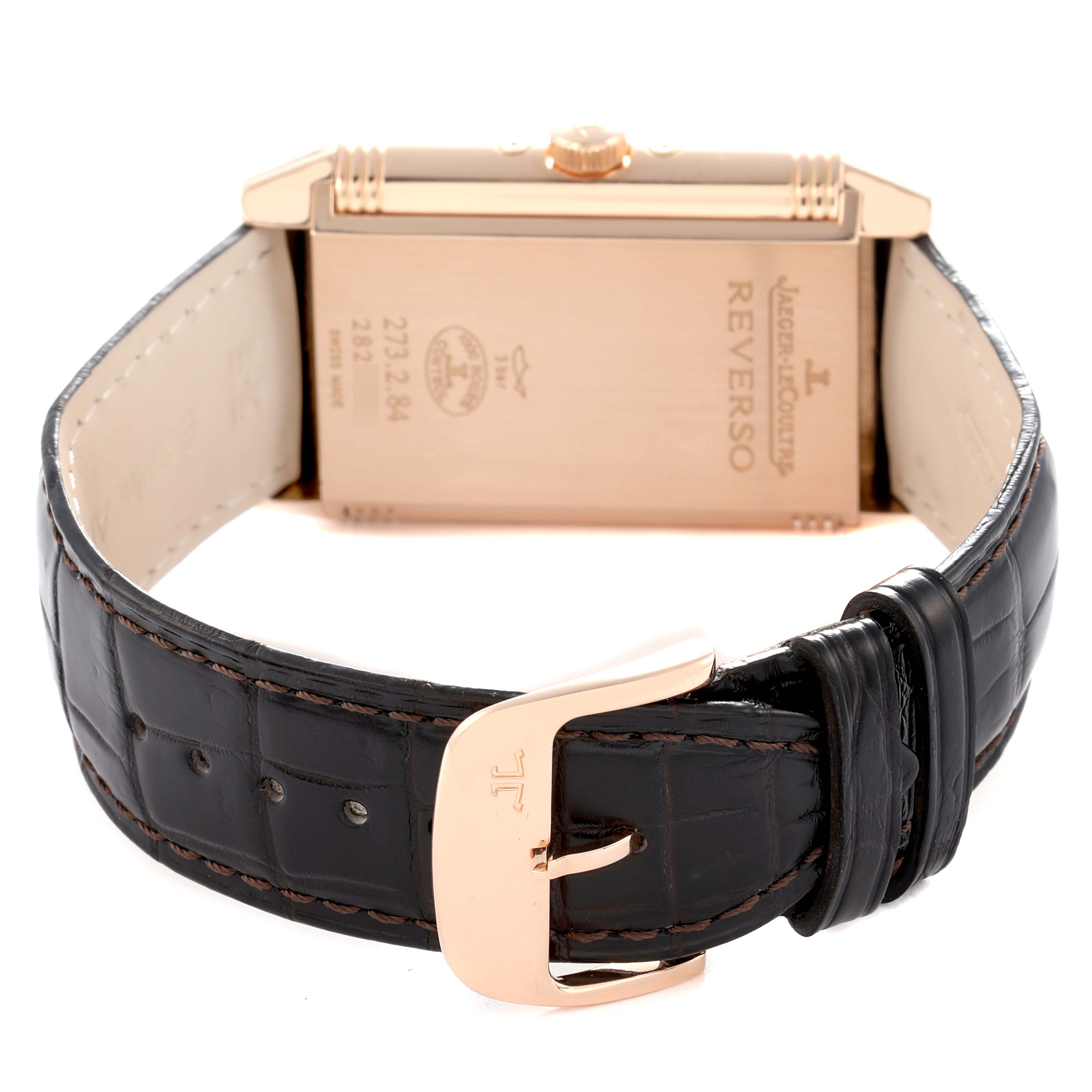 The image shows the back of a Jaeger-LeCoultre Reverso watch, highlighting the clasp and leather strap.