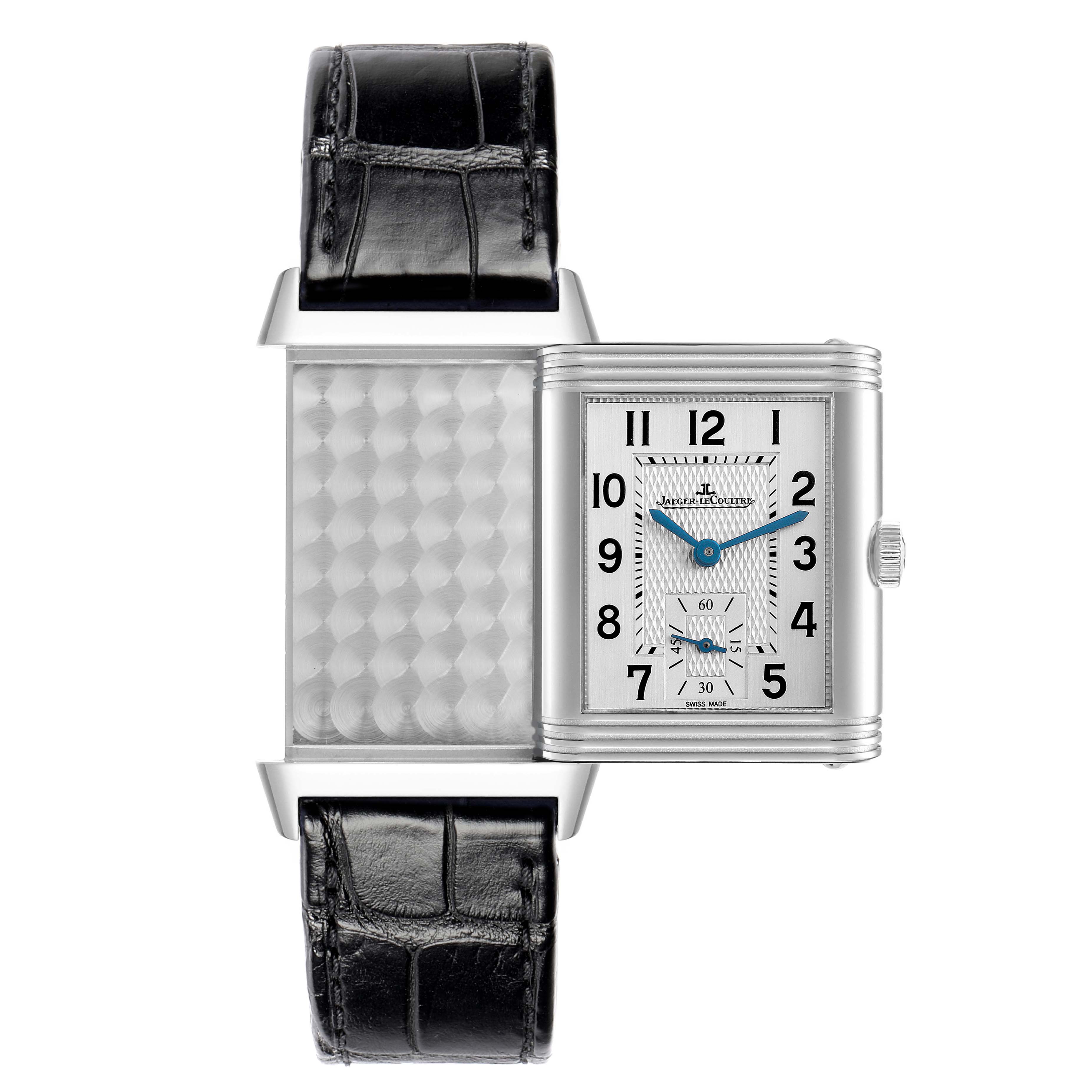 The Jaeger-LeCoultre Reverso watch is shown with its case flipped open, displaying both the dial and the patterned reverse side.