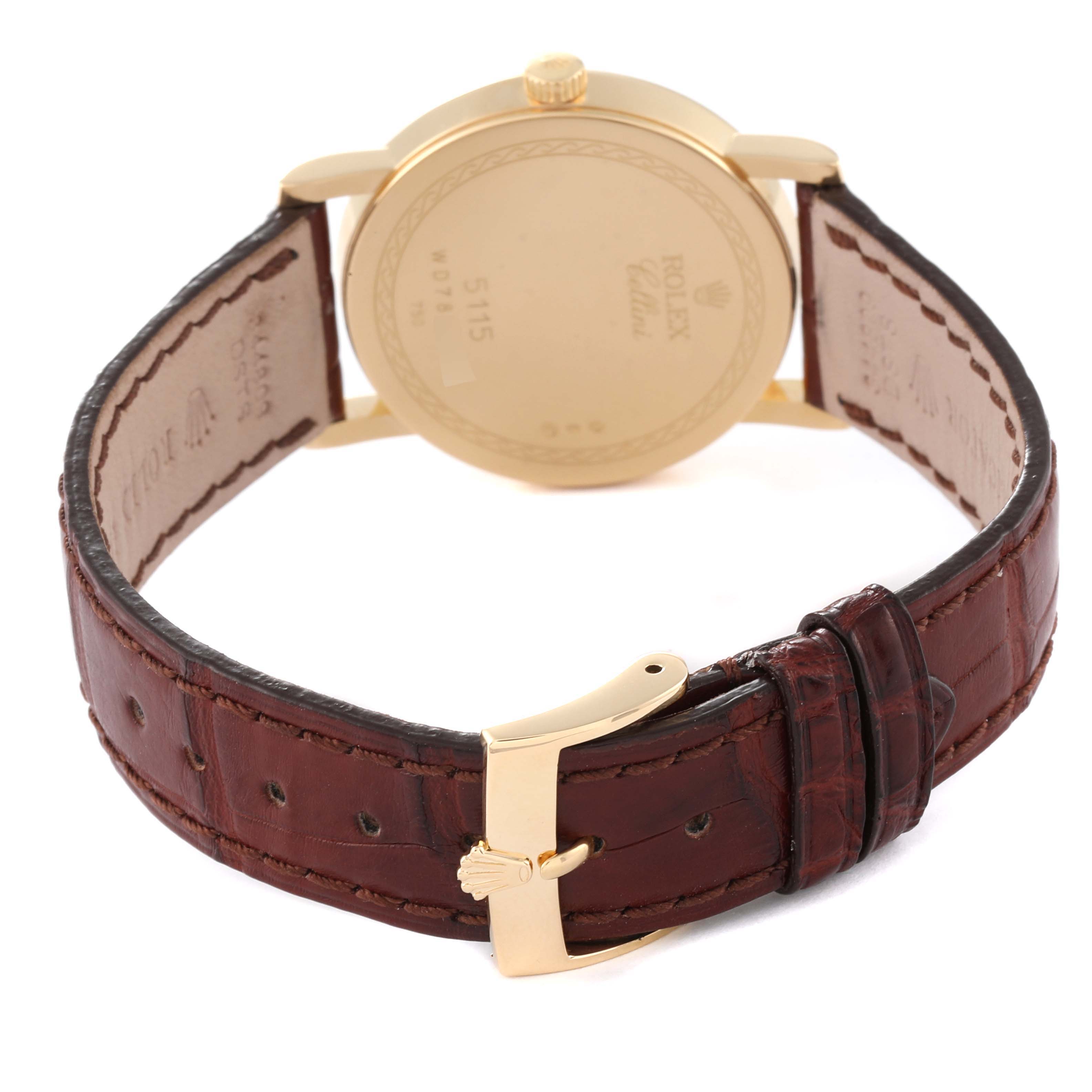 The image shows the back of a Rolex Cellini 5115 Men's Yellow Gold Champagne Dial 5115 Men's Yellow Gold Champagne Dial watch and its brown leather strap with a gold buckle.