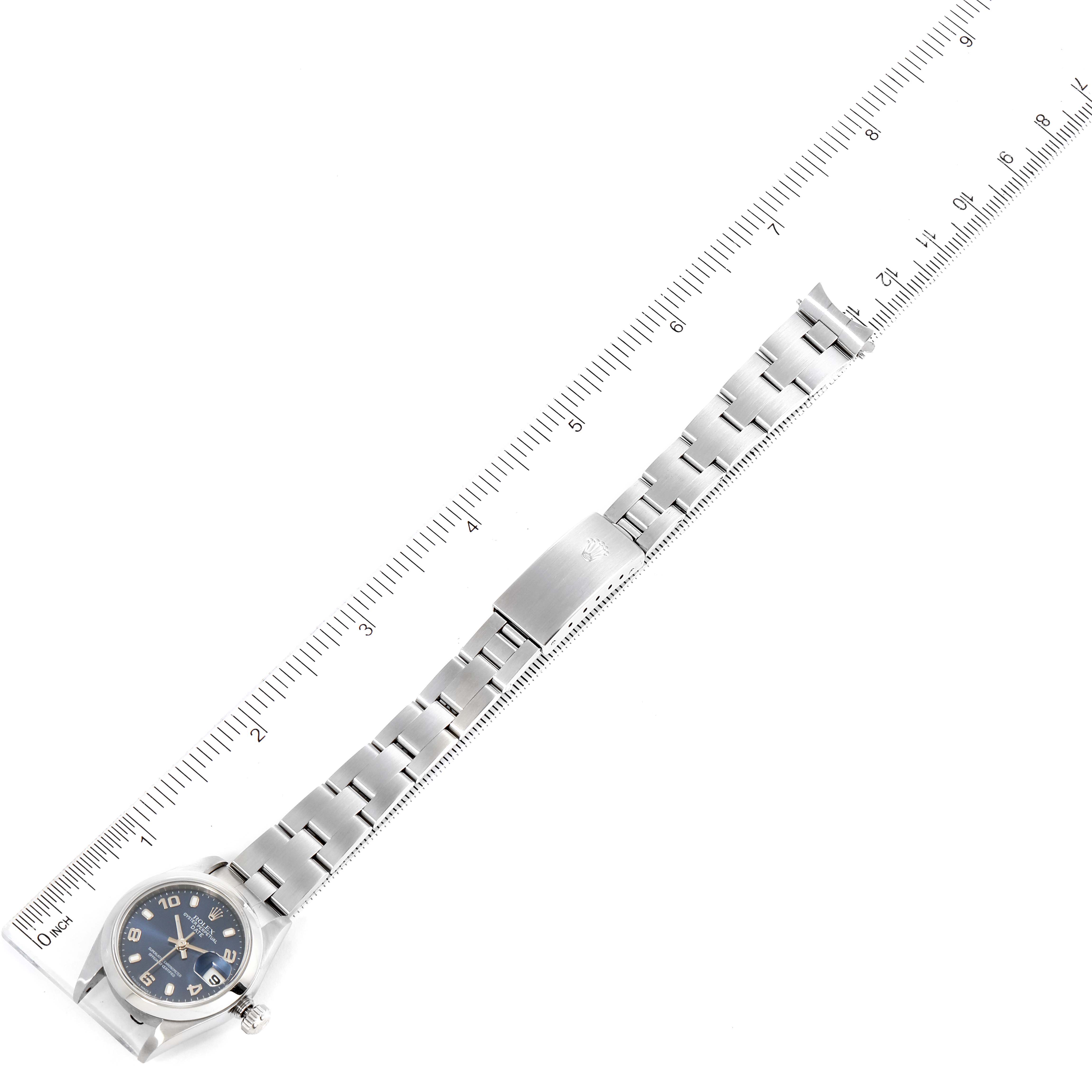 The image shows a top-down view of a Rolex Date 79160 Women's Stainless Steel Blue Dial 79160 Women's Stainless Steel Blue Dial model with a metal bracelet aligned along a ruler.