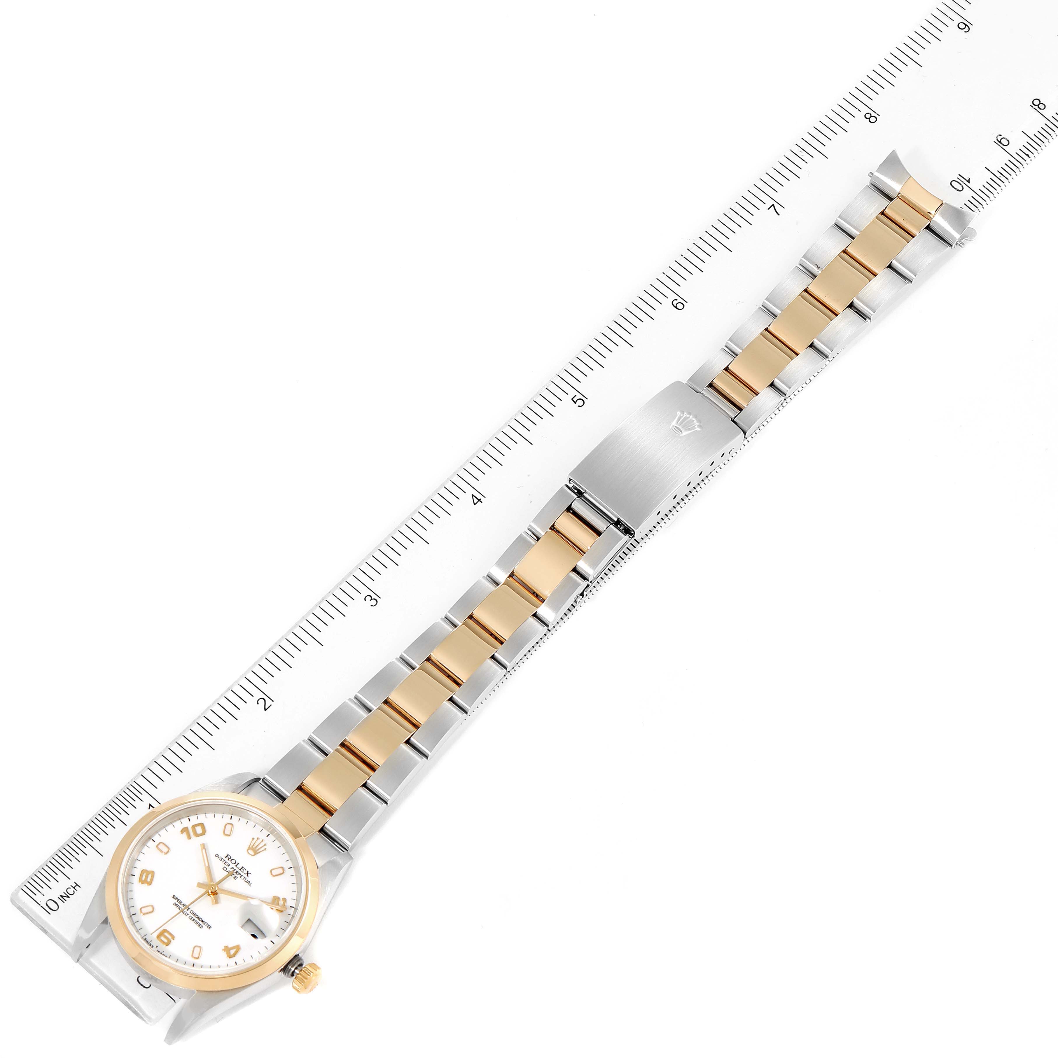 The image shows a Rolex Date 15203 Men's Steel and Gold (two tone) White Dial 15203 Men's Steel and Gold (two tone) White Dial model watch laid flat with its bracelet alongside a ruler for measurement.