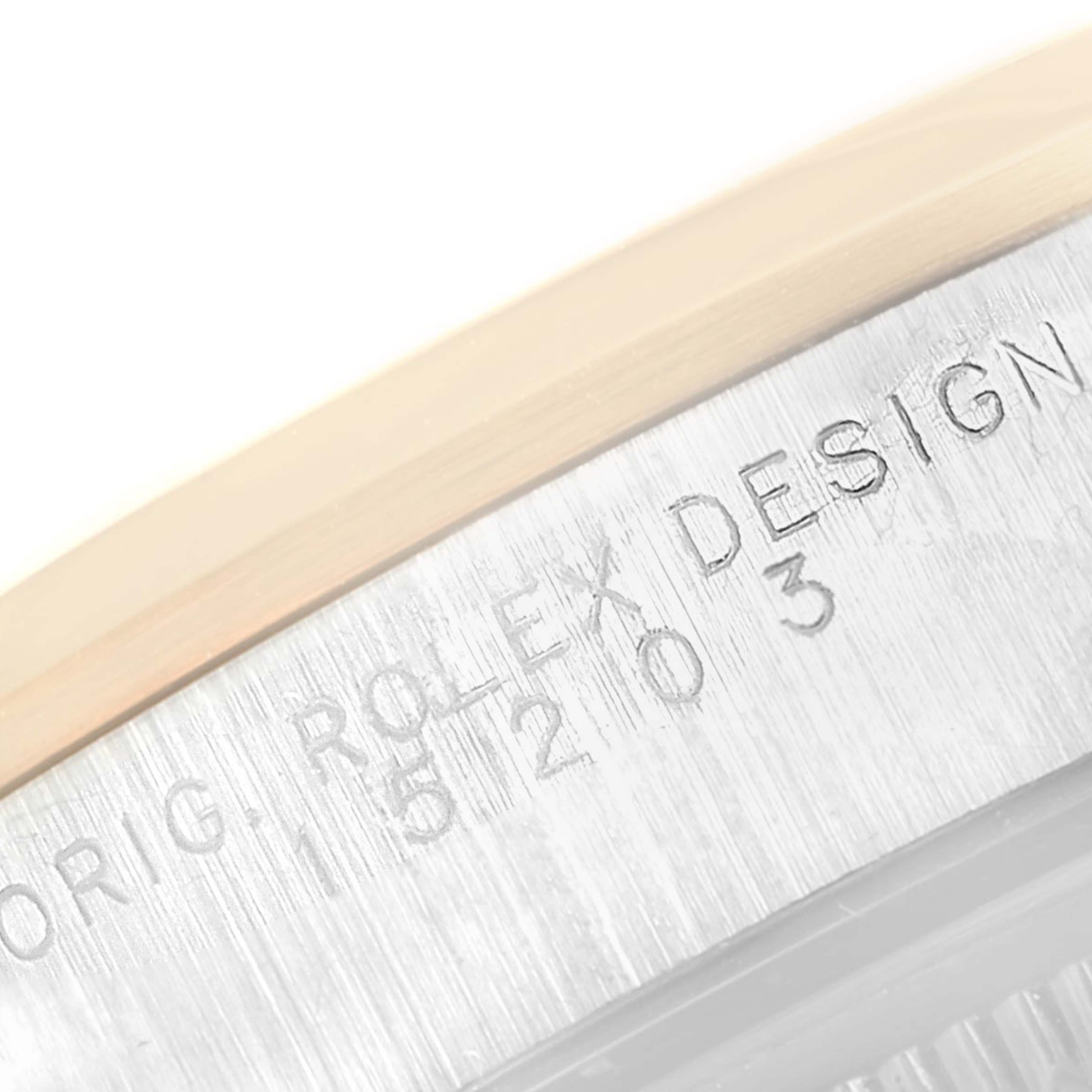 This is a macro shot showing the engravings on the side of the bezel of a Rolex Date 15203 Men's Steel and Gold (two tone) White Dial 15203 Men's Steel and Gold (two tone) White Dial model watch.