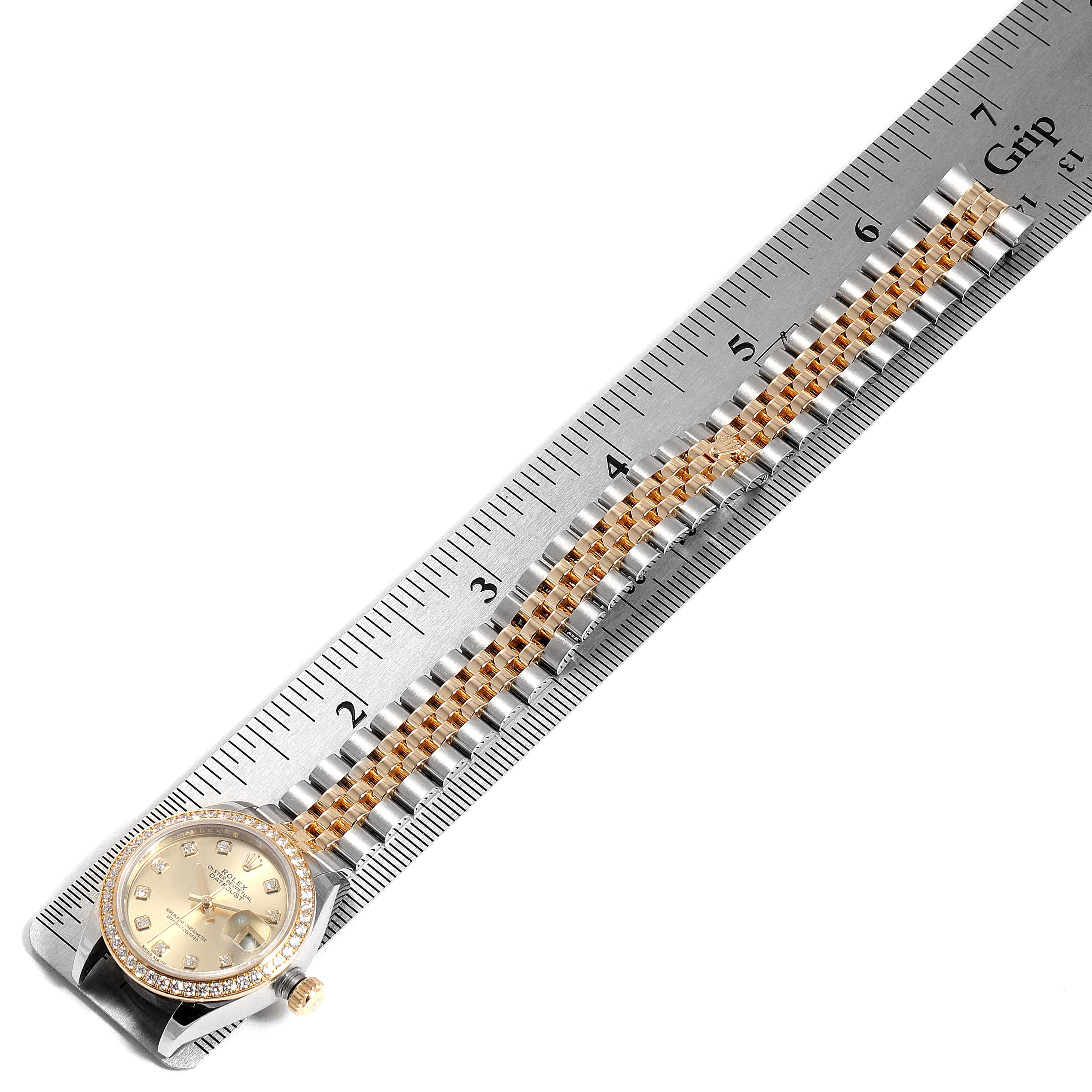 The Rolex Datejust 279383 Women
s Steel and Gold (two tone) Champagne Dial 279383 Women
s Steel and Gold (two tone) Champagne Dial watch is shown at a top-down angle, displaying the dial, bezel, and bracelet next to a ruler.