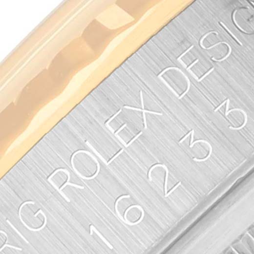 Close-up of the side of a Rolex Datejust 16233 Men's Steel and Gold (two tone) Black Dial 16233 Men's Steel and Gold (two tone) Black Dial watch, showing engraved model numbers and part of the bezel.