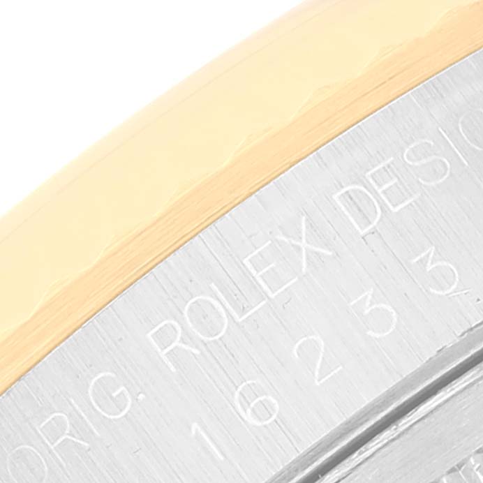 This image shows a close-up of the engraved bezel and case side of a Rolex Datejust 16233 Men's Steel and Gold (two tone) White Dial 16233 Men's Steel and Gold (two tone) White Dial watch.