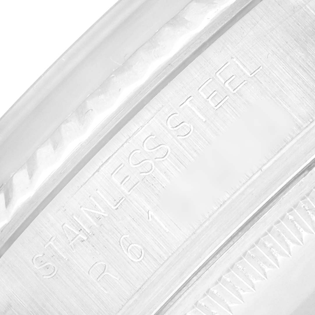 The image shows a close-up of the engraved edge of a Rolex Vintage Collection 16014 Men
s Stainless Steel Black Dial watch, focusing on the "Stainless Steel" marking.