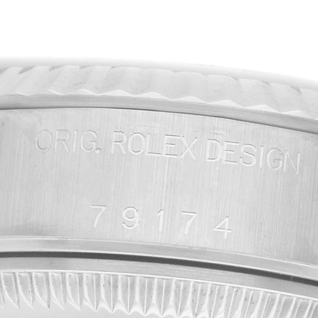 The image shows a close-up of the case side of a Rolex Datejust 79174 Women
s Stainless Steel Mother of Pearl Dial, highlighting the engraved design details and reference number.