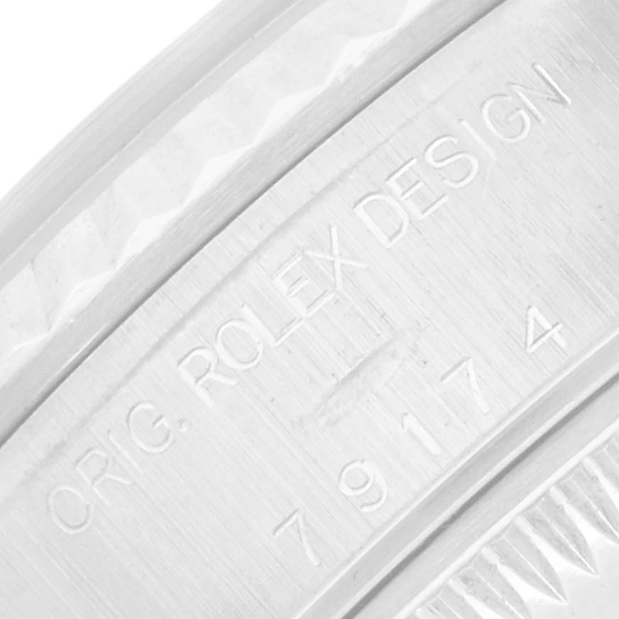The image shows a close-up angle of the engravings on the caseback edge of a Rolex Datejust 79174 Women
s Stainless Steel White Dial watch.