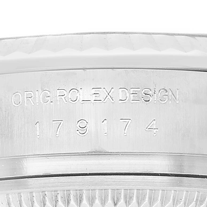 The image shows a close-up of the Rolex Datejust 179174 Women's Stainless Steel Blue Dial's case side, featuring engraving details.