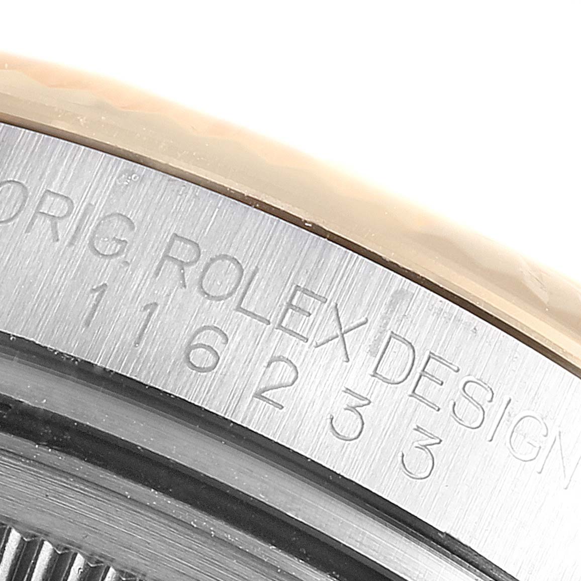 This close-up image shows the engraved model number and part of the bezel of a Rolex Datejust 116233 Men
s Steel and Gold (two tone) Black Dial 116233 Men
s Steel and Gold (two tone) Black Dial watch.