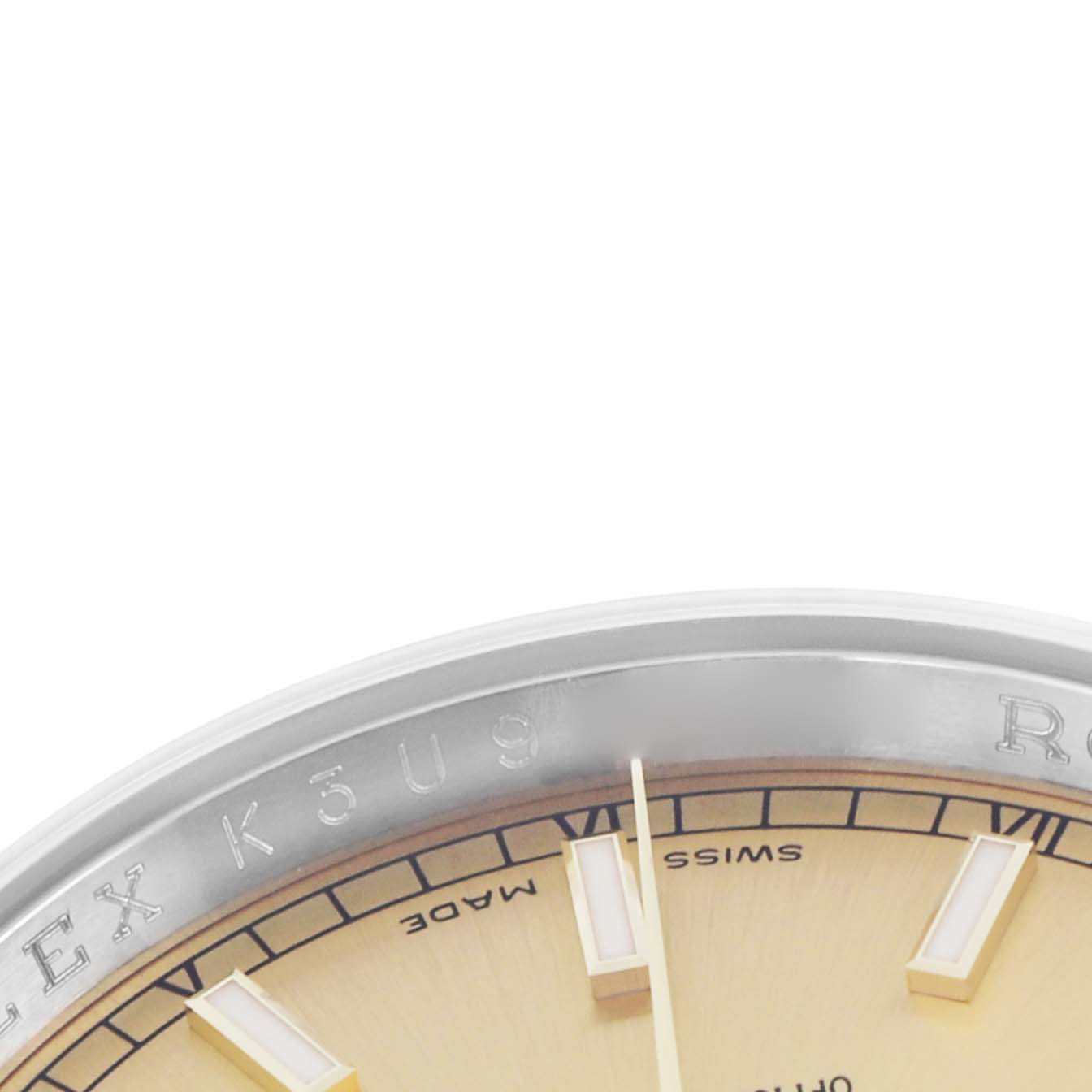 The image shows a partial view of the dial and bezel of a Rolex Datejust 116233 Men
s Steel and Gold (two tone) Champagne Dial, focusing on the top edge and indices.