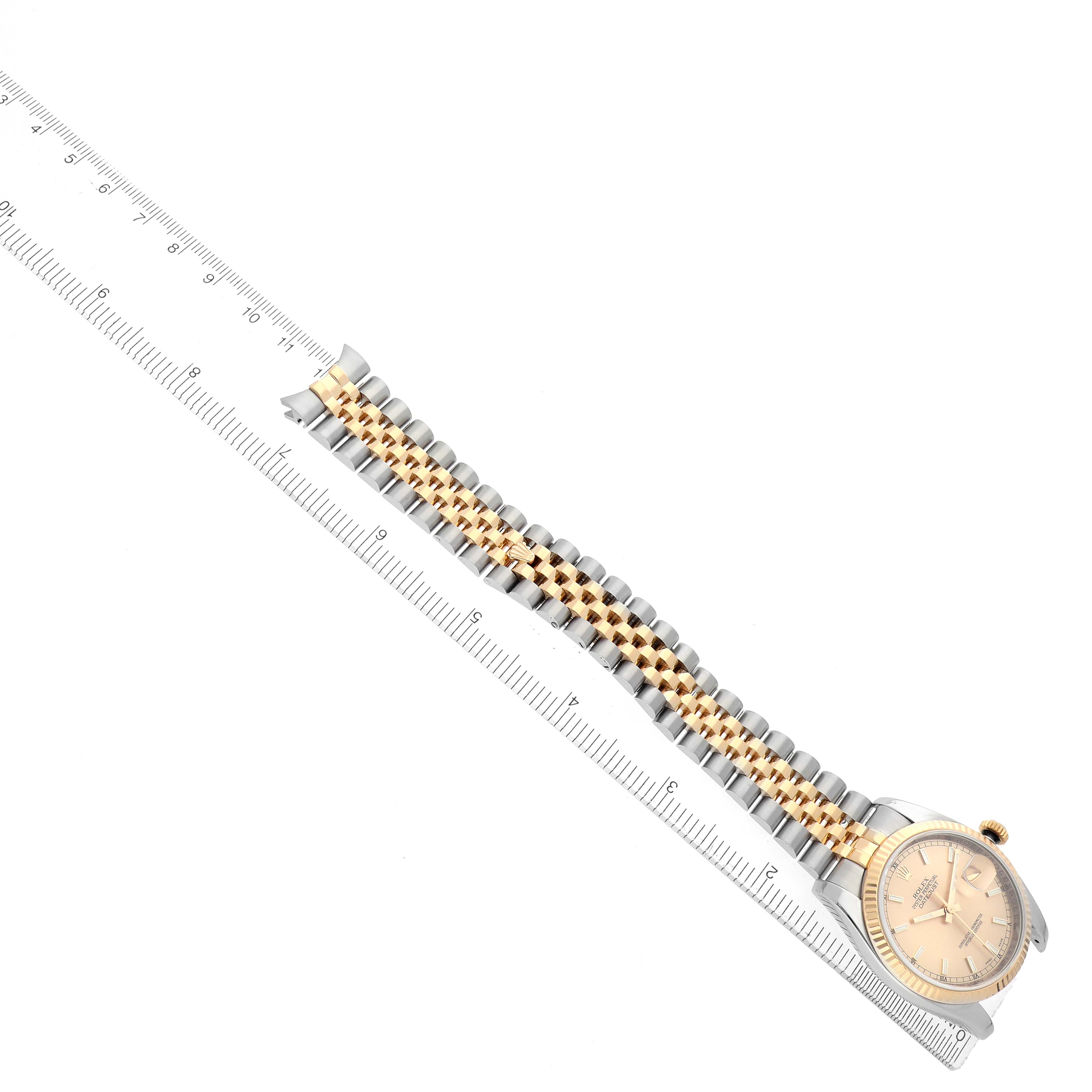 The image shows a Rolex Datejust 116233 Men
s Steel and Gold (two tone) Champagne Dial watch from an angled top view, with focus on the bracelet and ruler for scale.