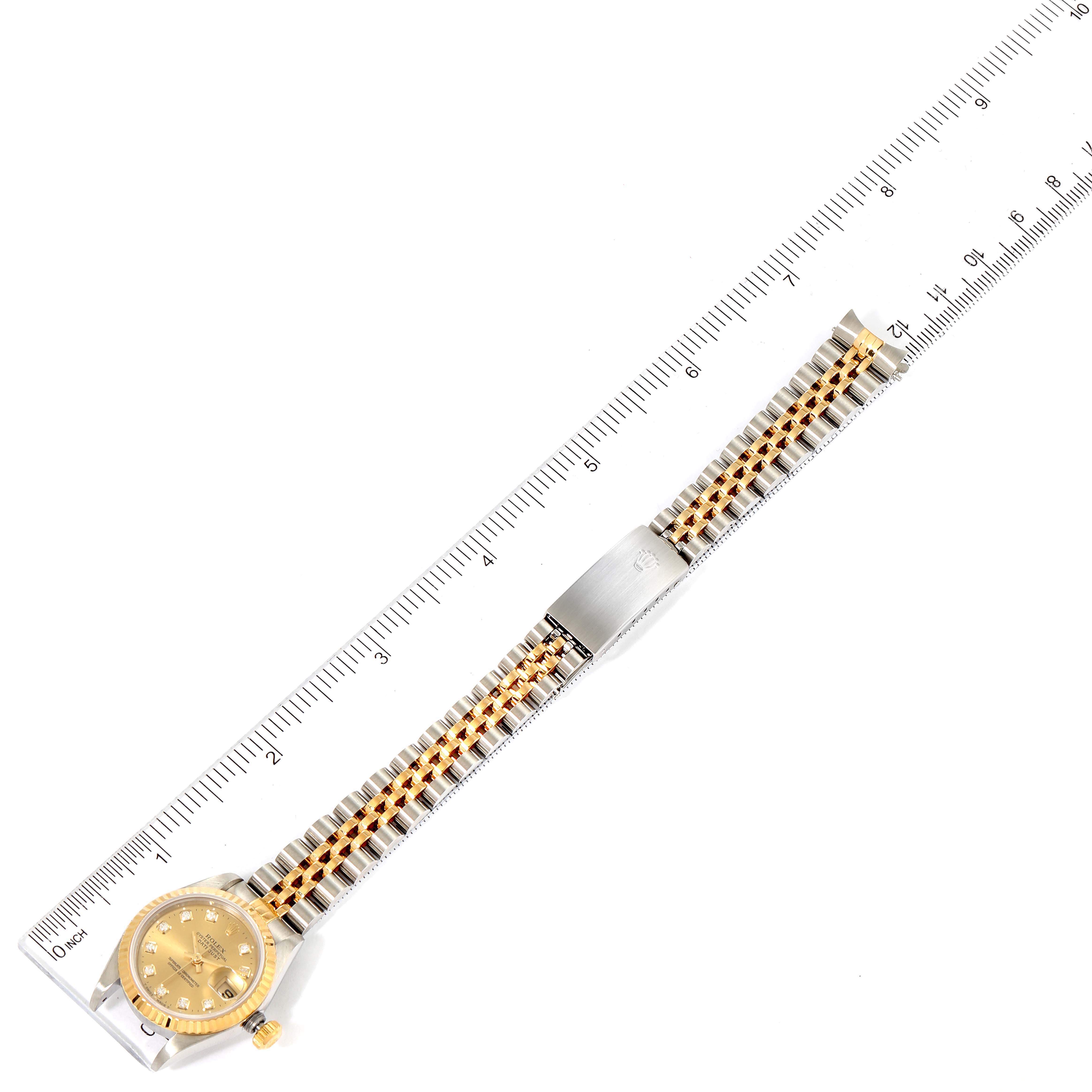 The image shows a Rolex Datejust 69173 Women's Steel and Gold (two tone) Champagne Dial 69173 Women's Steel and Gold (two tone) Champagne Dial watch placed parallel to a ruler, displaying its face, bracelet, and clasp.