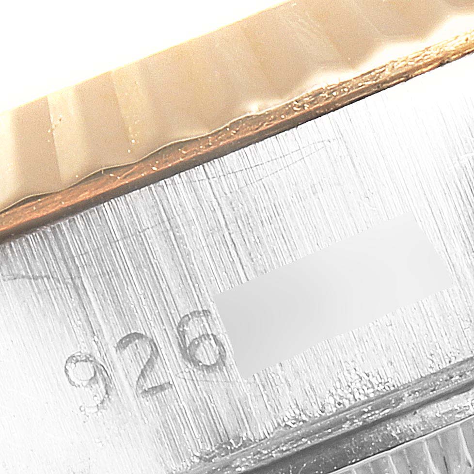 This close-up image shows the fluted bezel and part of the case of a Rolex Datejust 69173 Women
s Steel and Gold (two tone) Champagne Dial 69173 Women
s Steel and Gold (two tone) Champagne Dial watch, including an engraving.