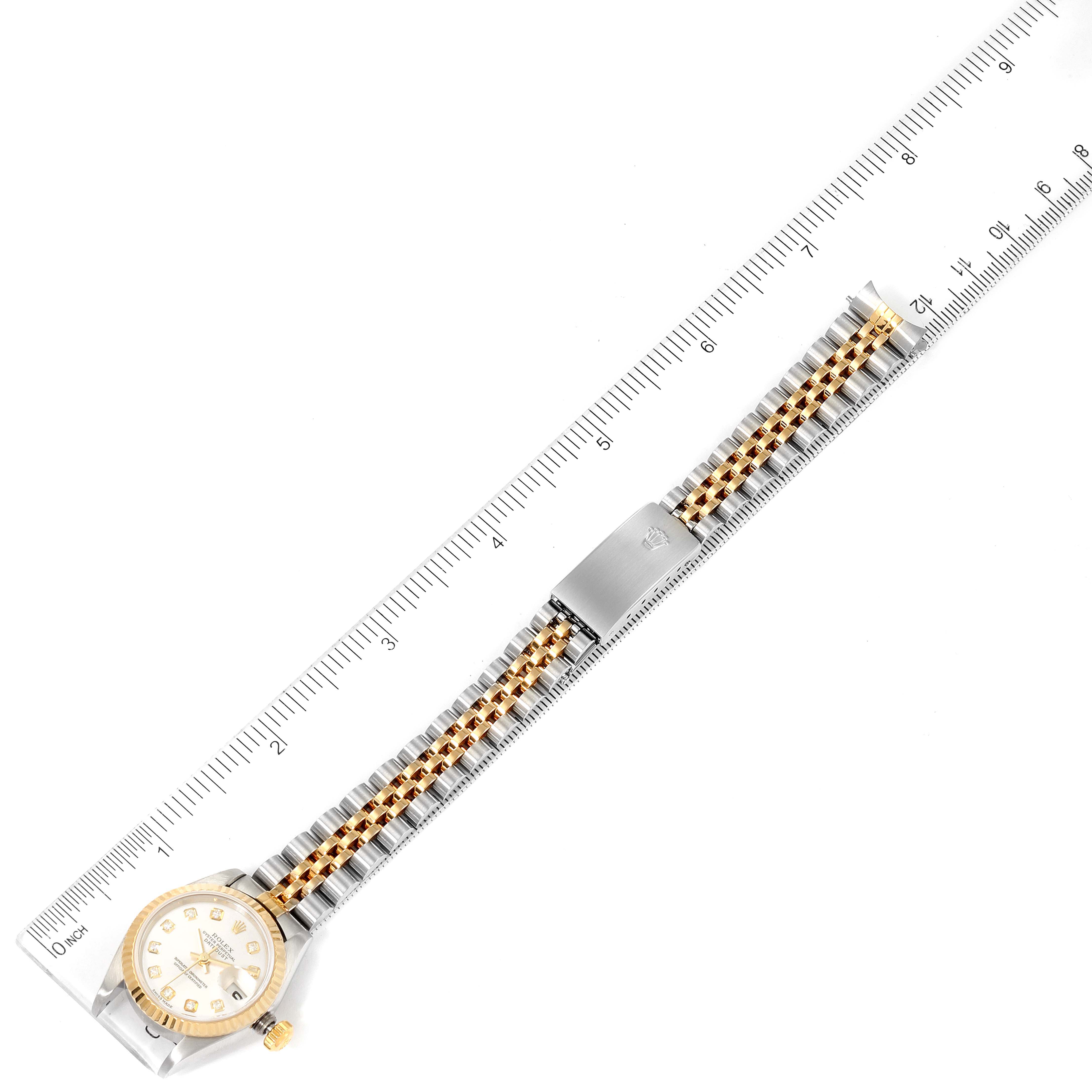 The Rolex Datejust 79173 Women
s Stainless Steel Silver Dial 79173 Women
s Stainless Steel Silver Dial watch is shown from an overhead angle with a detailed view of the watch face and bracelet, including a ruler for scale.