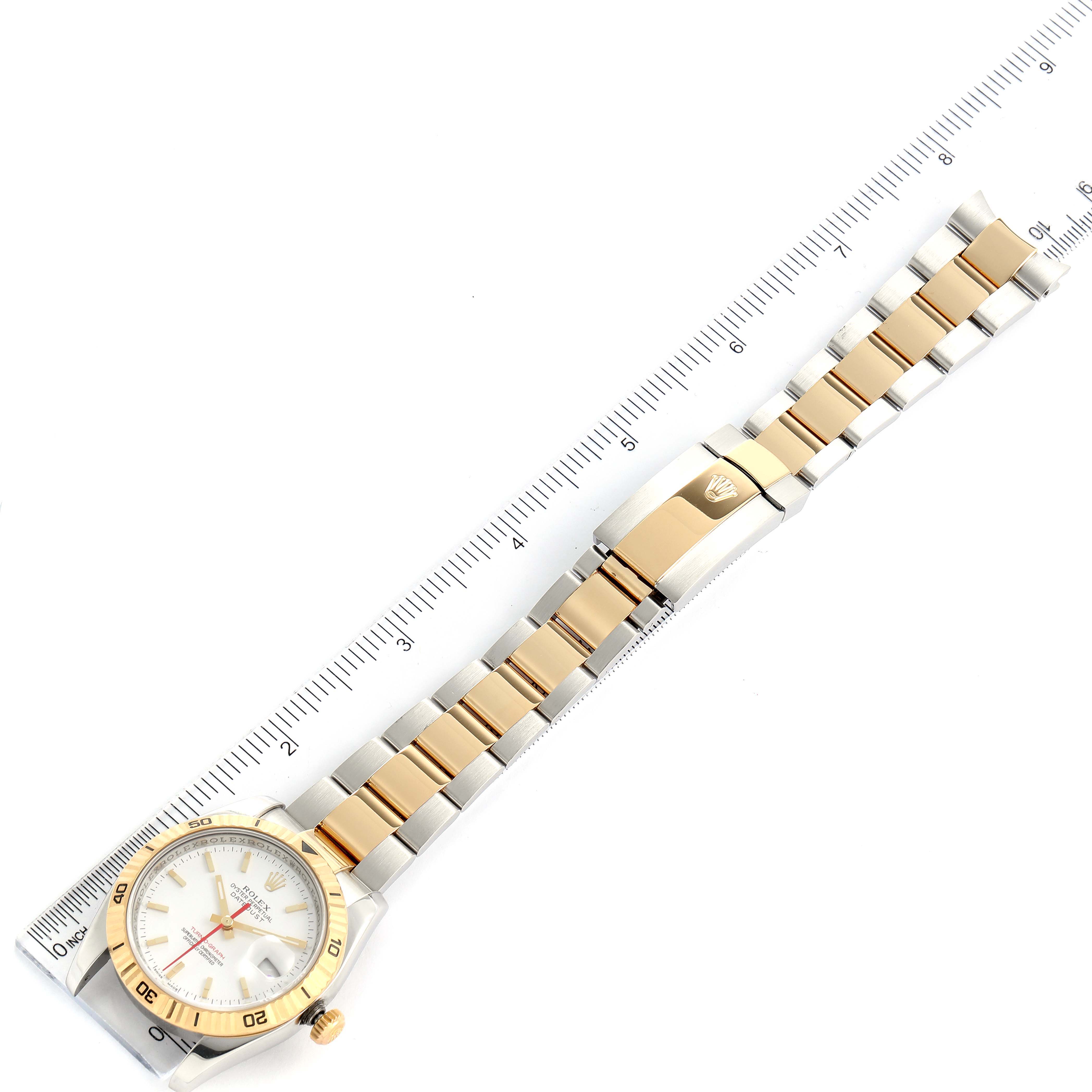 The Rolex Turn-o-Graph 116263 Men's Steel and Gold (two tone) White Dial 116263 Men's Steel and Gold (two tone) White Dial watch is shown from above, displaying the full watch, including the face, bezel, and bracelet alongside a ruler.