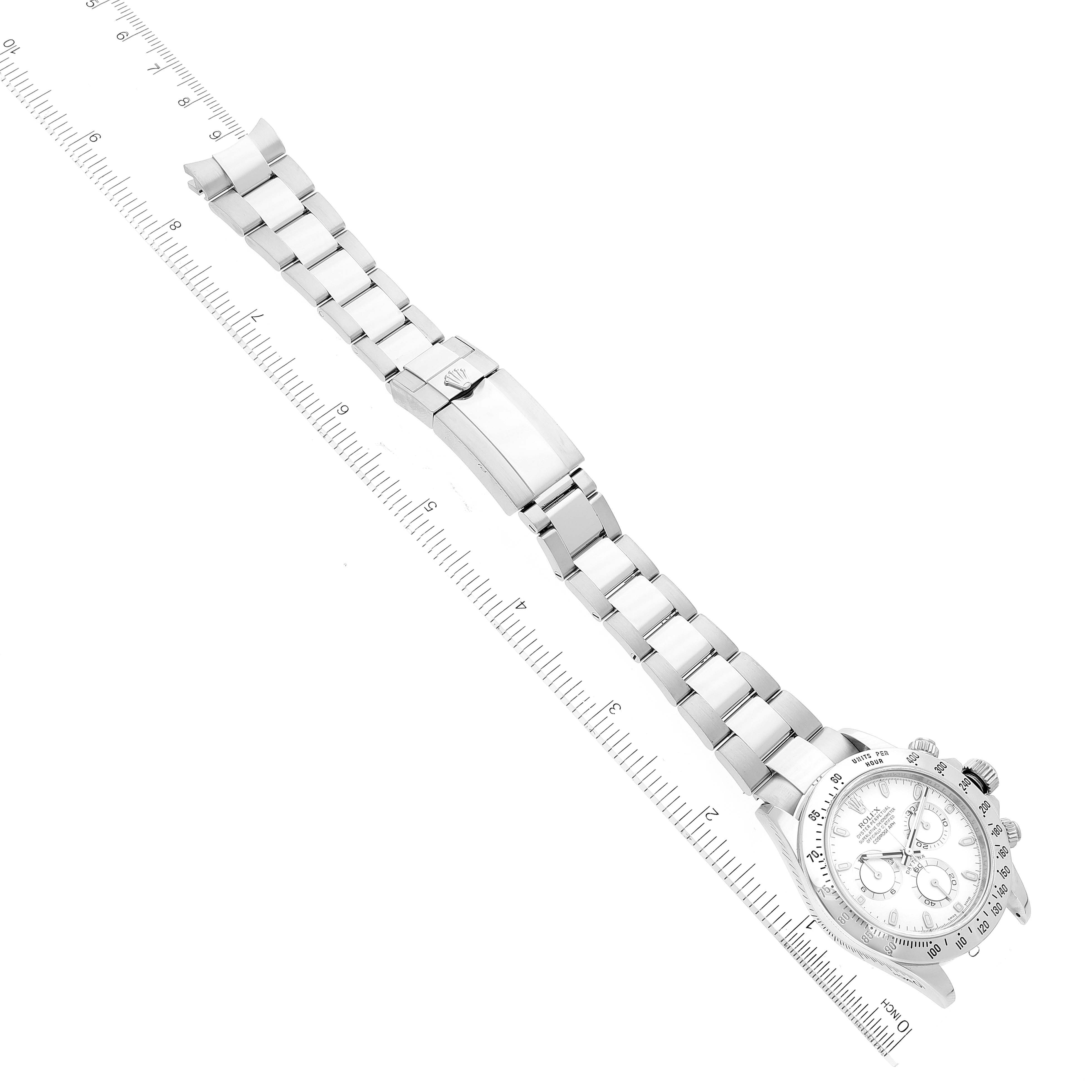 The image shows a Rolex Daytona 116520 Men's Stainless Steel White Dial 116520 Men's Stainless Steel White Dial watch laid flat with the face and band fully visible next to a ruler.