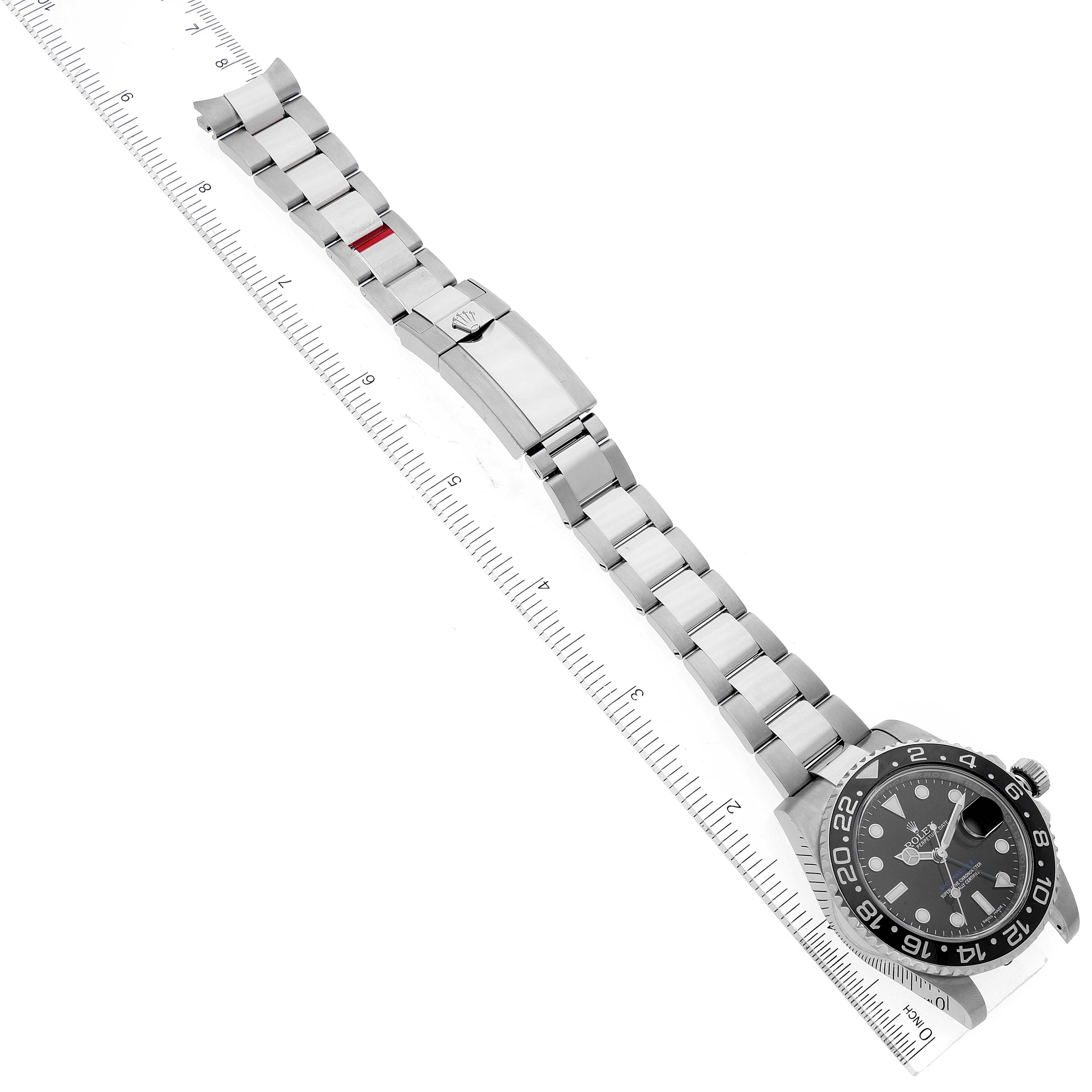 This image shows a top-down view of a Rolex GMT-Master 116710 Men's Stainless Steel Black Dial 116710 Men's Stainless Steel Black Dial watch, displaying the bracelet, clasp, and face with ruler for scale.