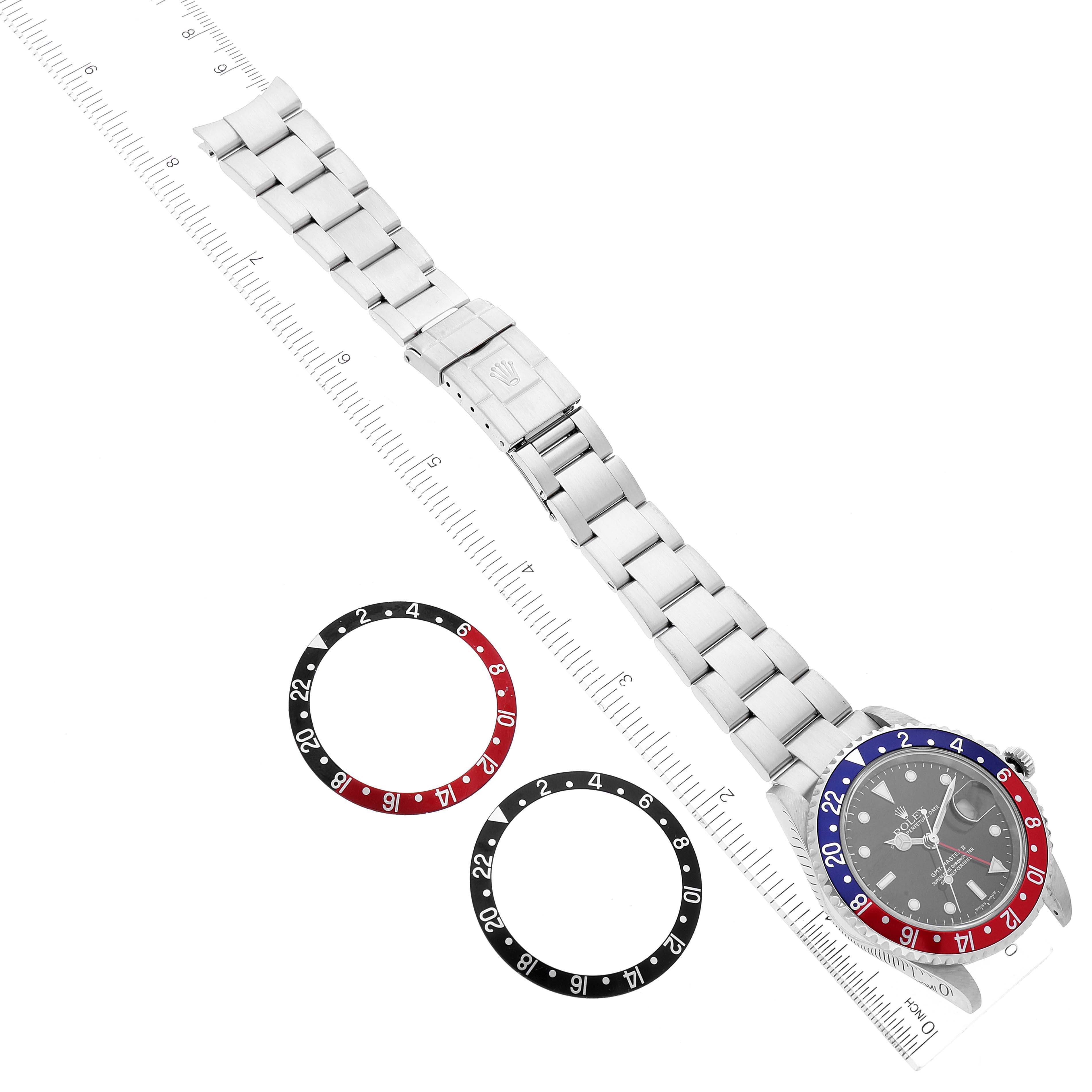 The image shows a top-down view of a Rolex GMT-Master 16710 Men
s Stainless Steel Black Dial 16710 Men
s Stainless Steel Black Dial watch and two separate bezels next to it.