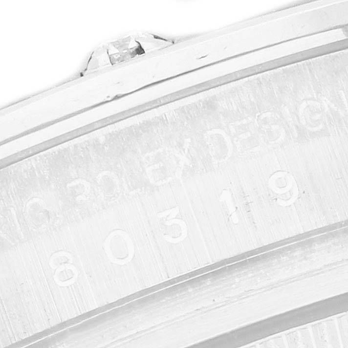 The image shows a close-up of the side engraving on a Rolex Pearlmaster 80319 Women
s White Gold Mother of Pearl Dial watch, focusing on the design details and serial number.