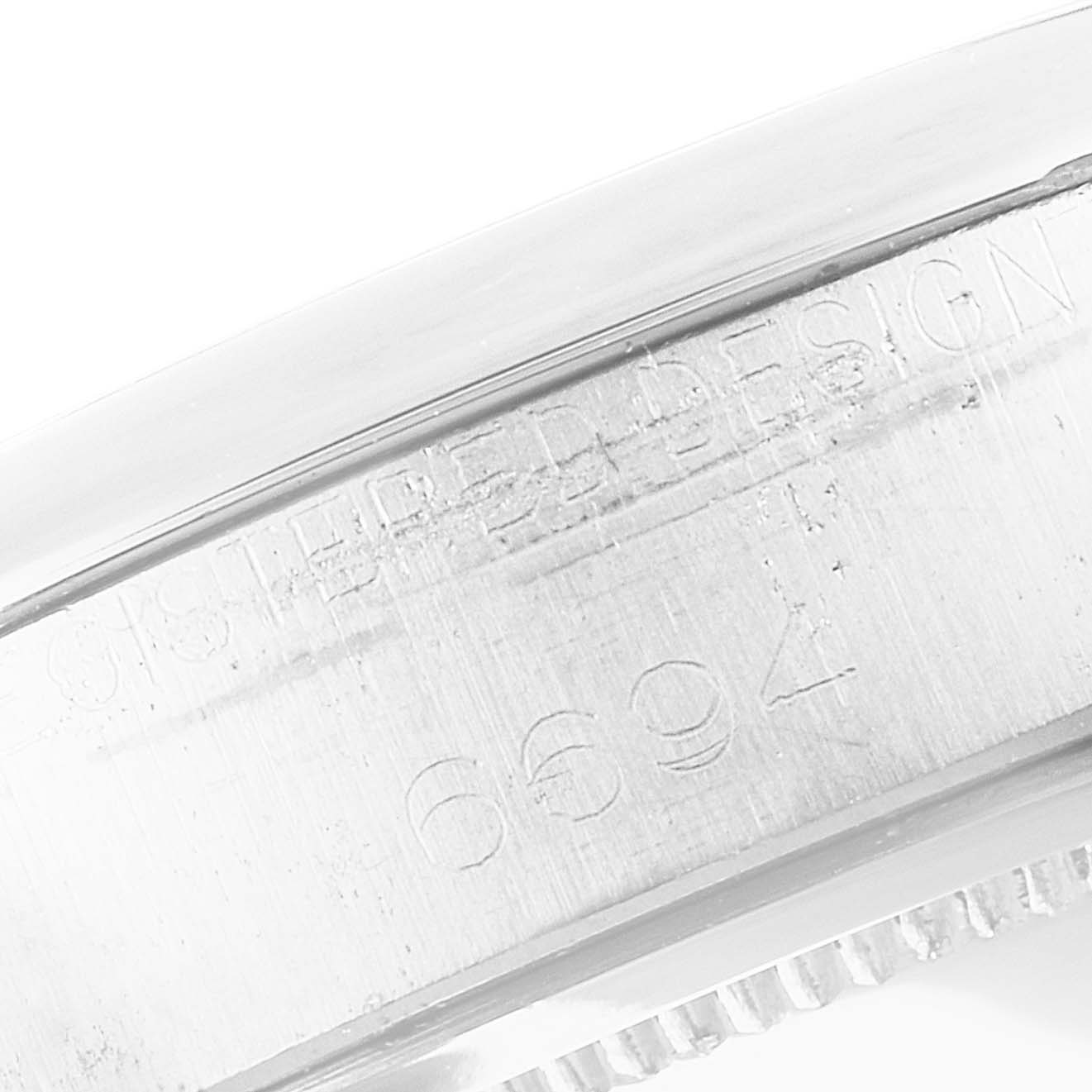 This image shows a close-up of the engraved serial number on the casing of a Rolex Date 6694 Men's Stainless Steel Black Dial 6694 Men's Stainless Steel Black Dial model watch.