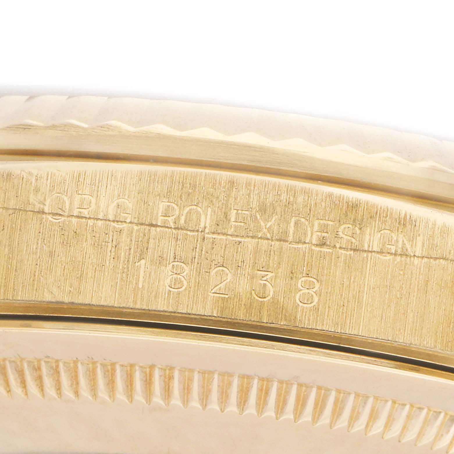 The image shows a close-up of the side of a Rolex President 18238 Men
s Yellow Gold Champagne Dial model with visible engravings on the metal case.