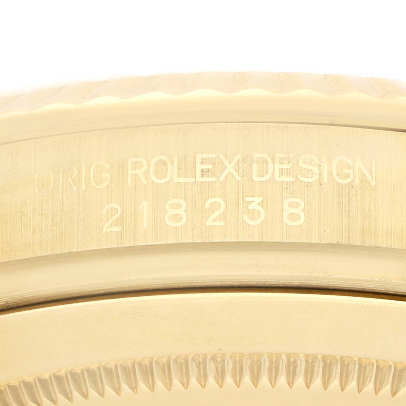 The image shows a close-up of the side engraving on a Rolex Daytona 218238 Men
s Yellow Gold Champagne Dial, highlighting its model number.