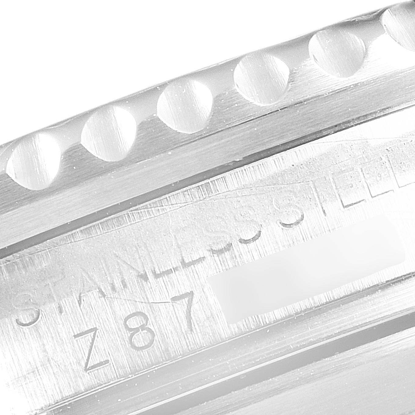 The image shows a close-up of the side of a Rolex Submariner 16610 Men
s Stainless Steel Black Dial 16610 Men
s Stainless Steel Black Dial watch, highlighting its stainless steel material and part of the serial number.