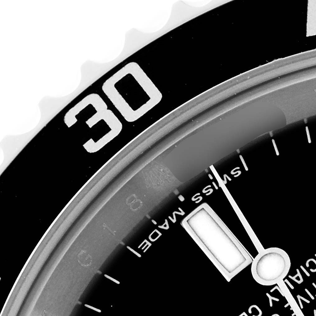 Close-up of the Rolex Submariner 14060M Men
s Stainless Steel Black Dial 14060M Men
s Stainless Steel Black Dial bezel, part of the dial displaying "SWISS MADE," and part of the hour hand.
