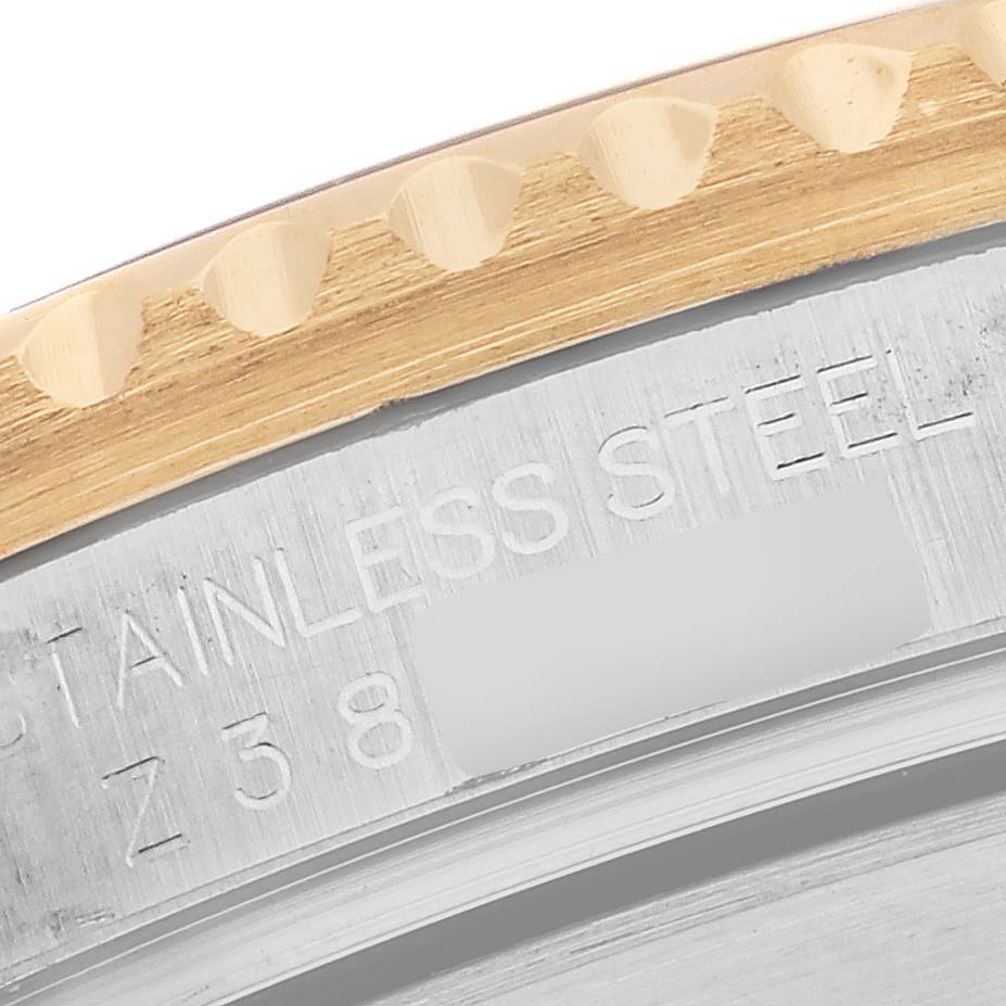 This close-up image of a Rolex Submariner 16613 Men's Steel and Gold (two tone) Champagne Dial 16613 Men's Steel and Gold (two tone) Champagne Dial watch shows part of the stainless steel case and the edge of the bezel.