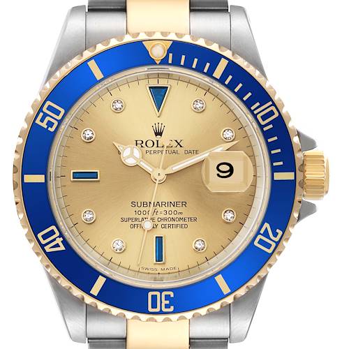 The image shows a frontal view of a Rolex Submariner watch, featuring a blue bezel, gold dial, and a two-tone bracelet.