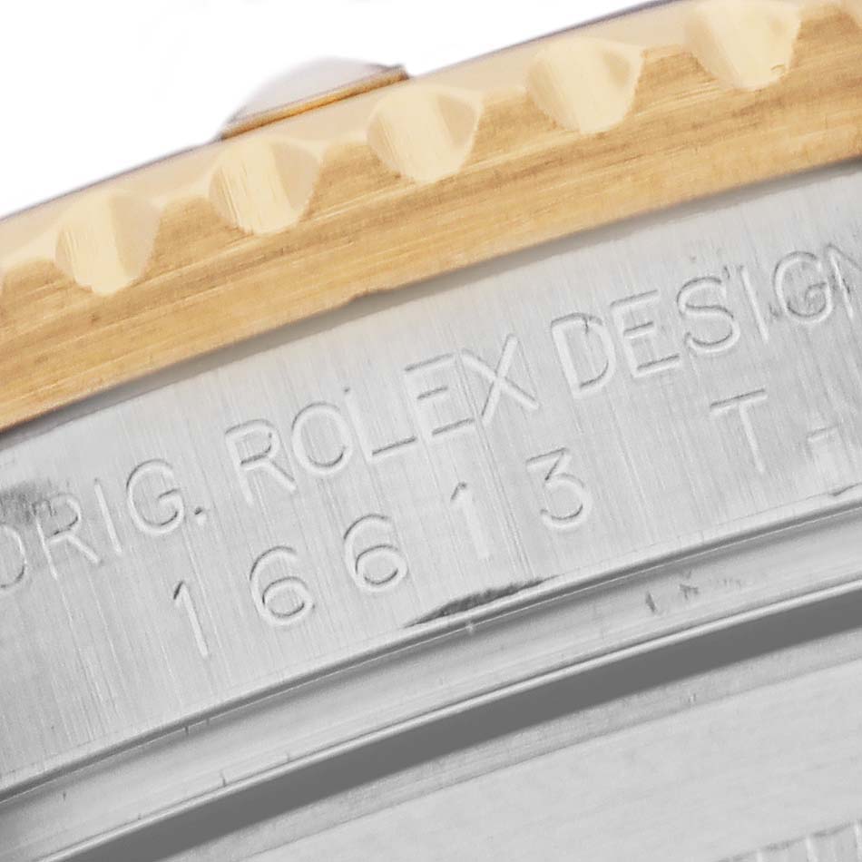 This is a close-up shot of the side of the Rolex Submariner 16613 Men's Steel and Gold (two tone) Champagne Dial 16613 Men's Steel and Gold (two tone) Champagne Dial watch, showing the etched model number and part of the bezel.
