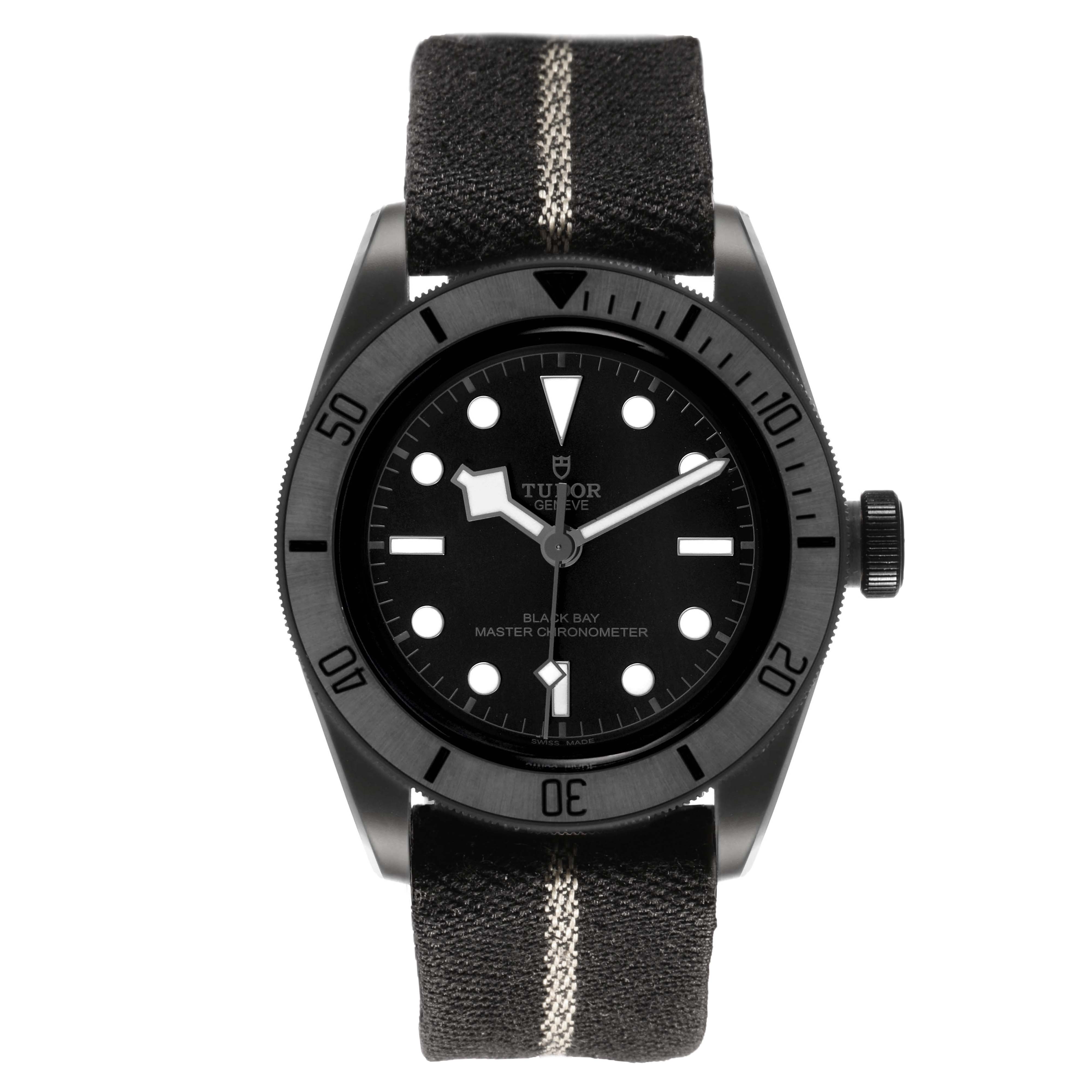 The Tudor Heritage Black Bay M79210CNU Men's Ceramic Black Dial watch is shown from a front angle, featuring its bezel, dial, hands, and fabric strap.