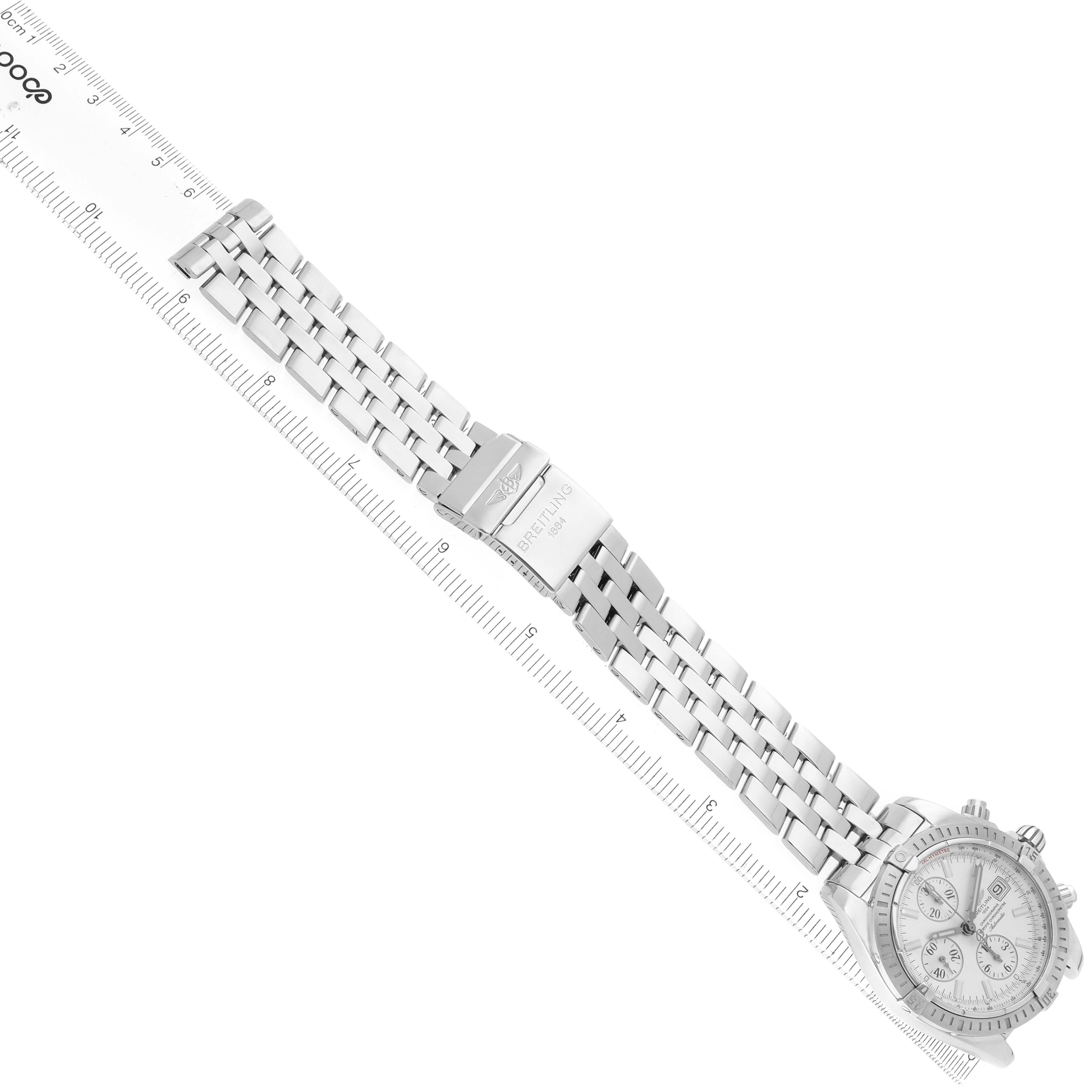 The Breitling Chronomat A13356 Men
s Stainless Steel Silver Dial watch is displayed diagonally, showing its stainless steel bracelet and face, with a ruler indicating length.