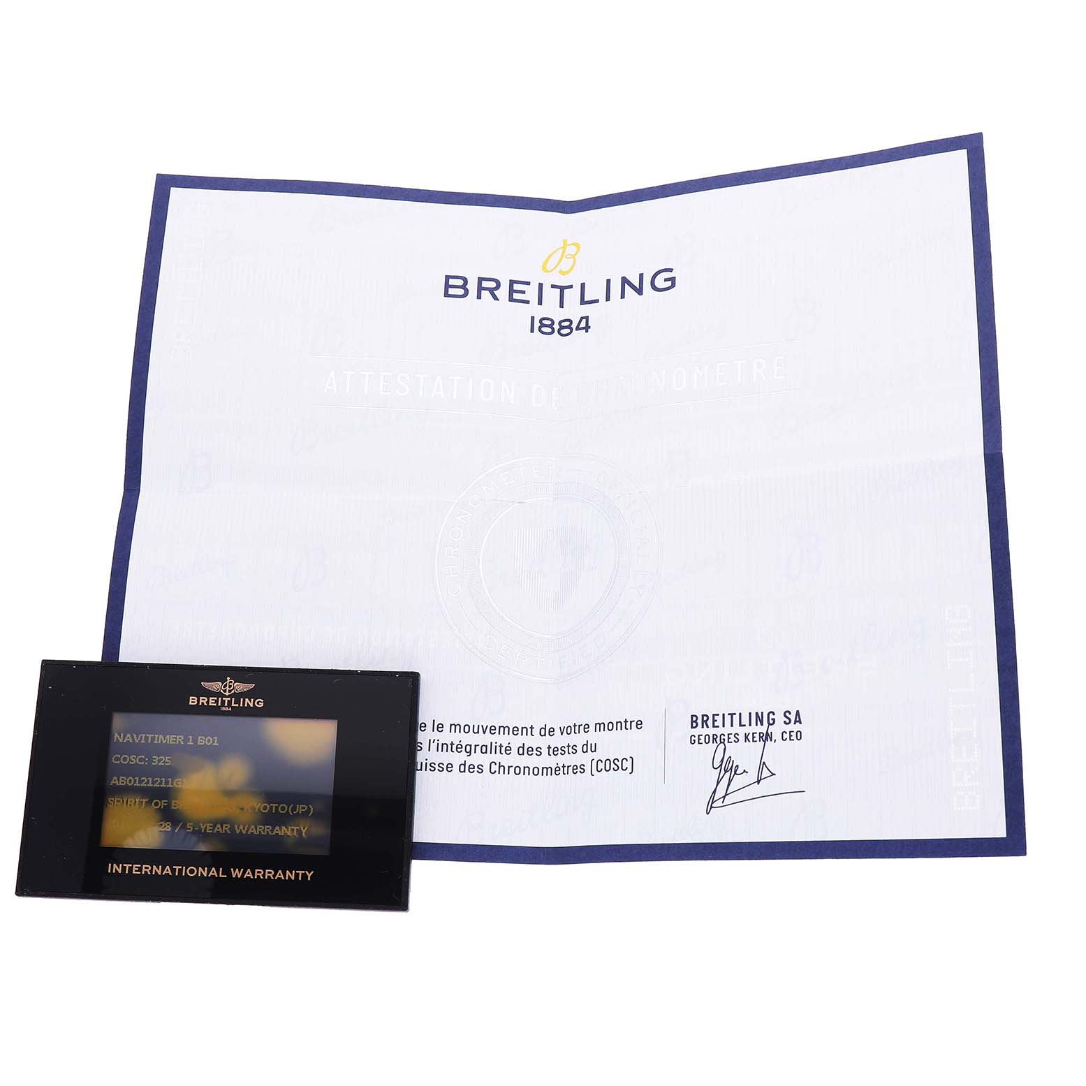 The image shows a Breitling Navitimer AB0121 Men's Stainless Steel Silver Dial certificate and an international warranty card from a top view.