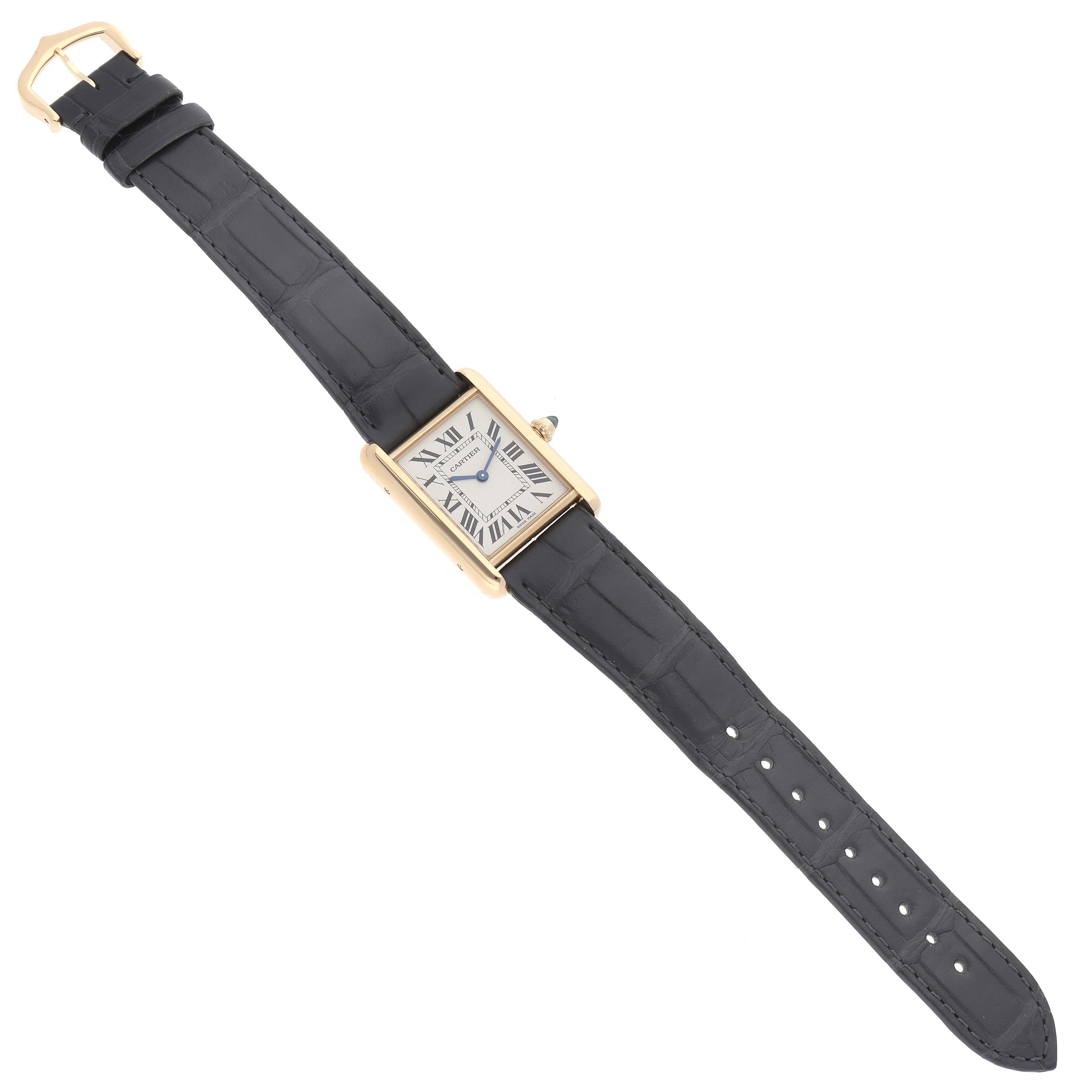 The Cartier Tank Louis WGTA0067 Men's Yellow Gold Silver Dial WGTA0067 Men's Yellow Gold Silver Dial watch is displayed fully extended, showcasing its face, strap, and buckle from a top-down angle.