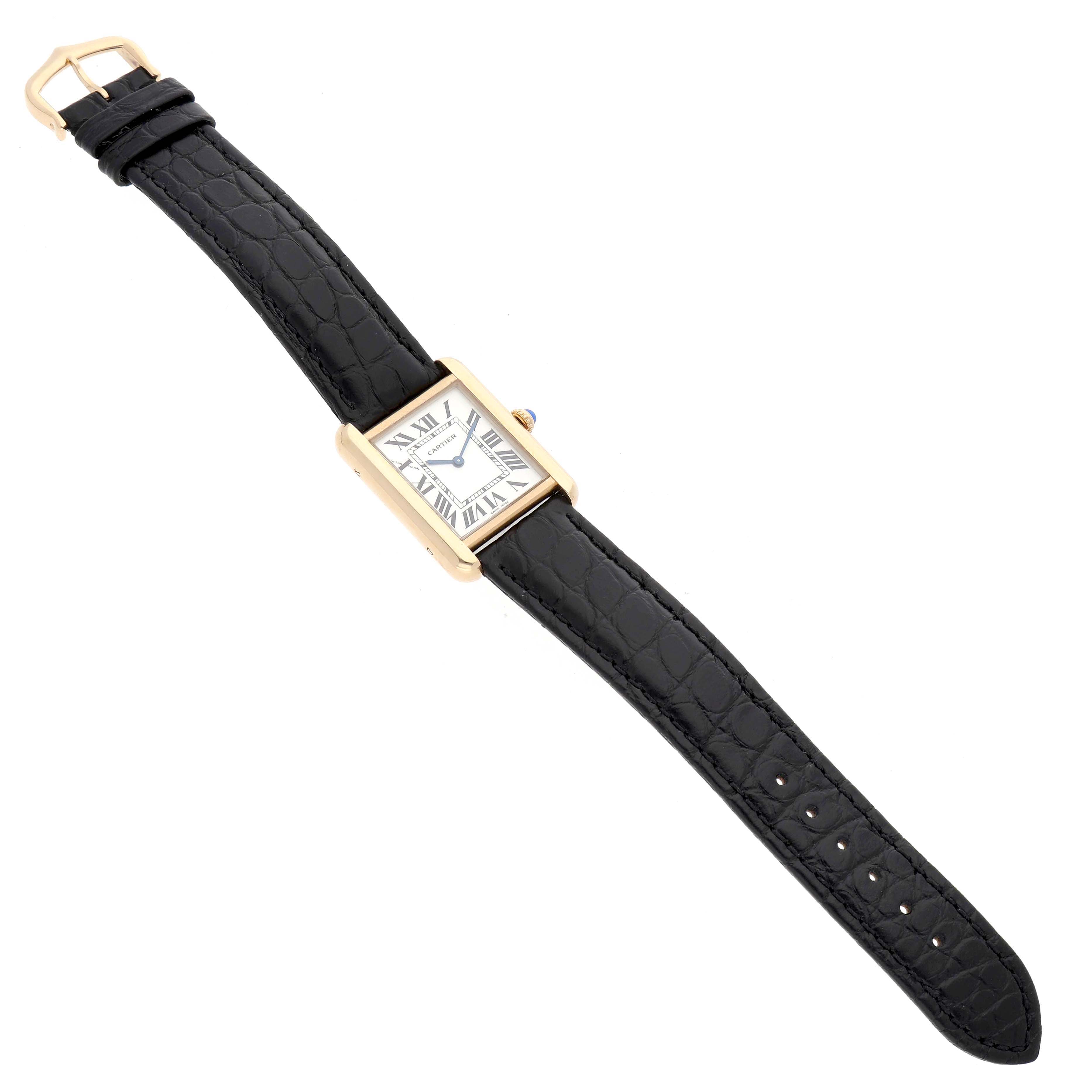 The Cartier Tank Solo W1018755 Women's Yellow Gold Silver Dial watch is shown from a top-down angle, displaying its rectangular face, gold case, and black leather strap.