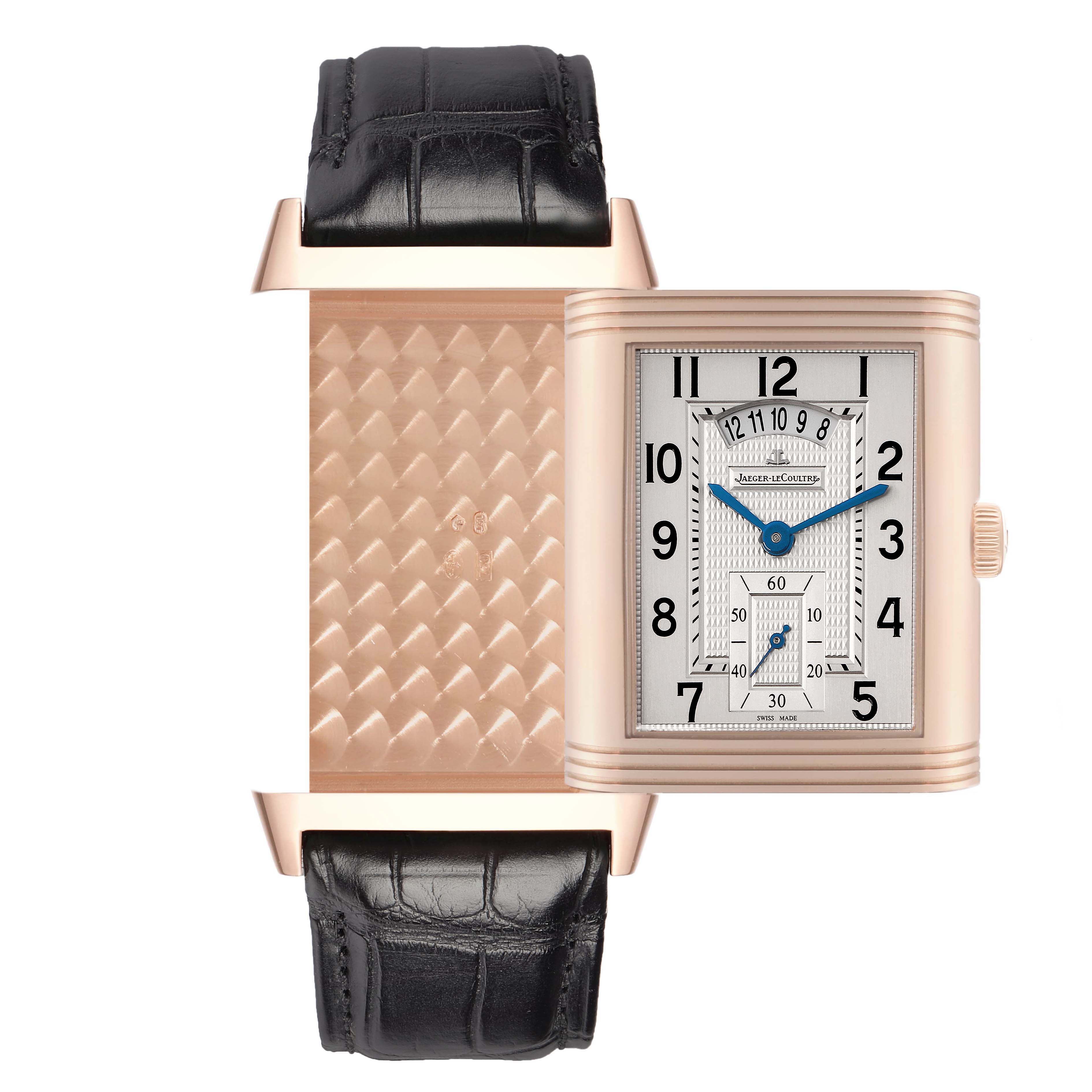 The Jaeger-LeCoultre Reverso watch is shown with its case turned, displaying both the dial and textured case back.