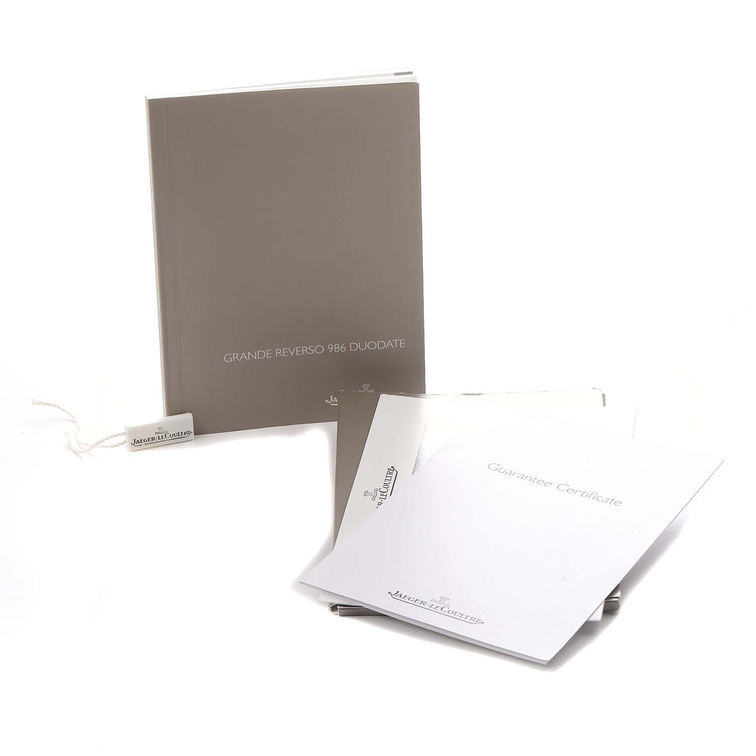 The image shows Jaeger LeCoultre Reverso Q3742421 Men's Rose Gold Silver Dial model's manuals, guarantee certificate, and a tag.