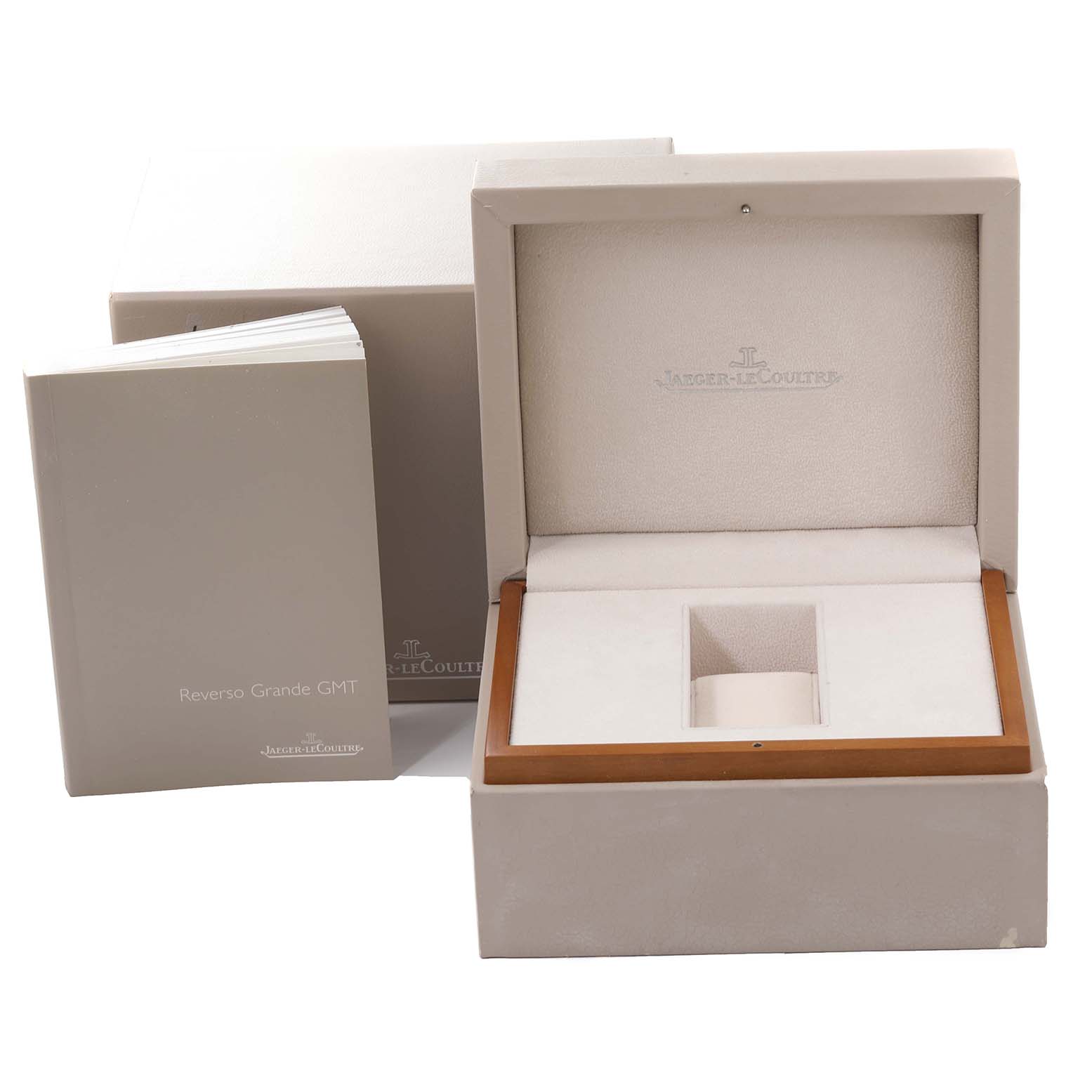 This image shows an open Reverso model watch box by Jaeger LeCoultre and its accompanying manual.